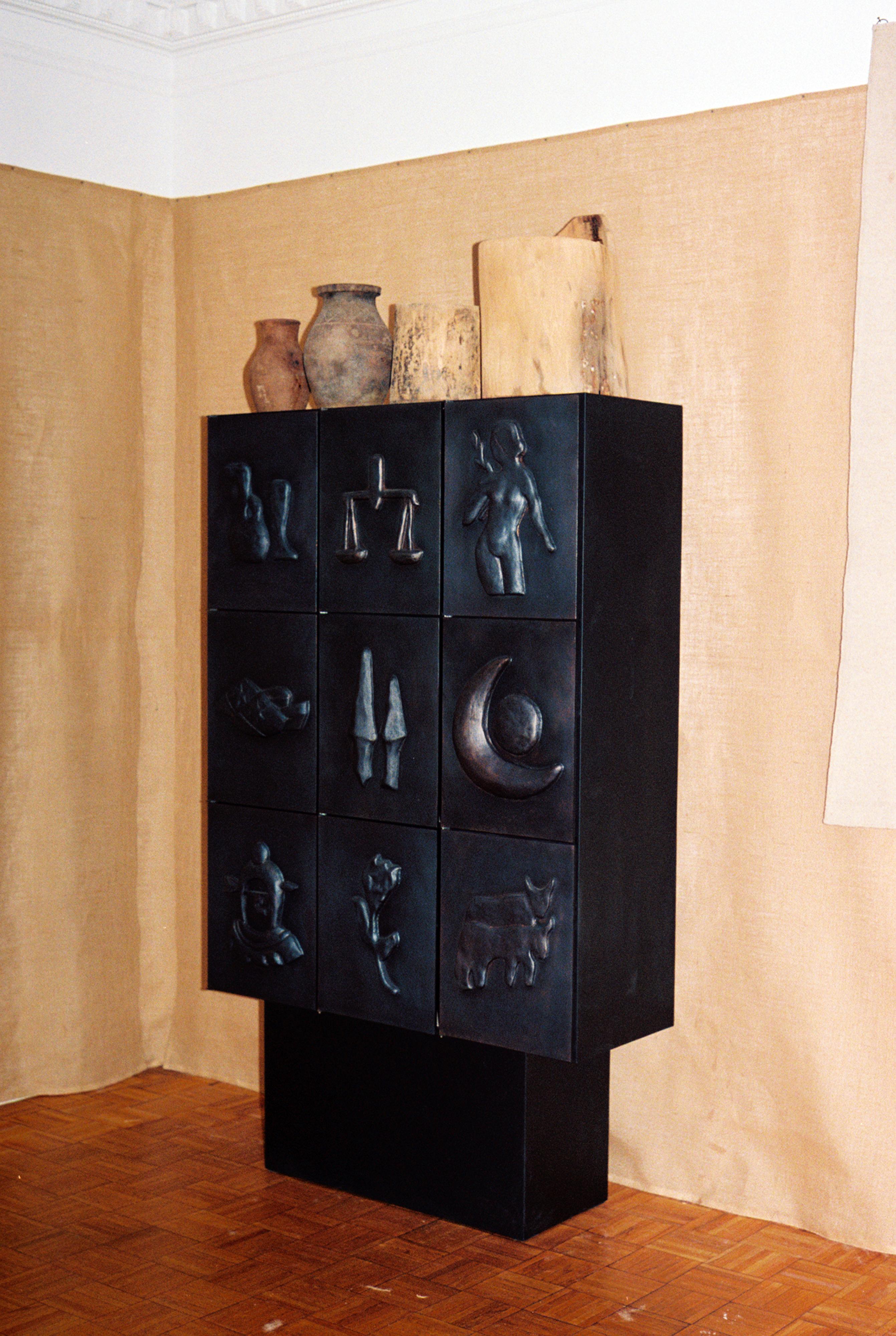 This elegant and  wood, metal, and copper cabinet adorned with blackened copper low-relief motifs is created with expert construction by the design duo Rooms Studio from Tbilisi, Georgia. Each door of the handmade black metal cabinet features a