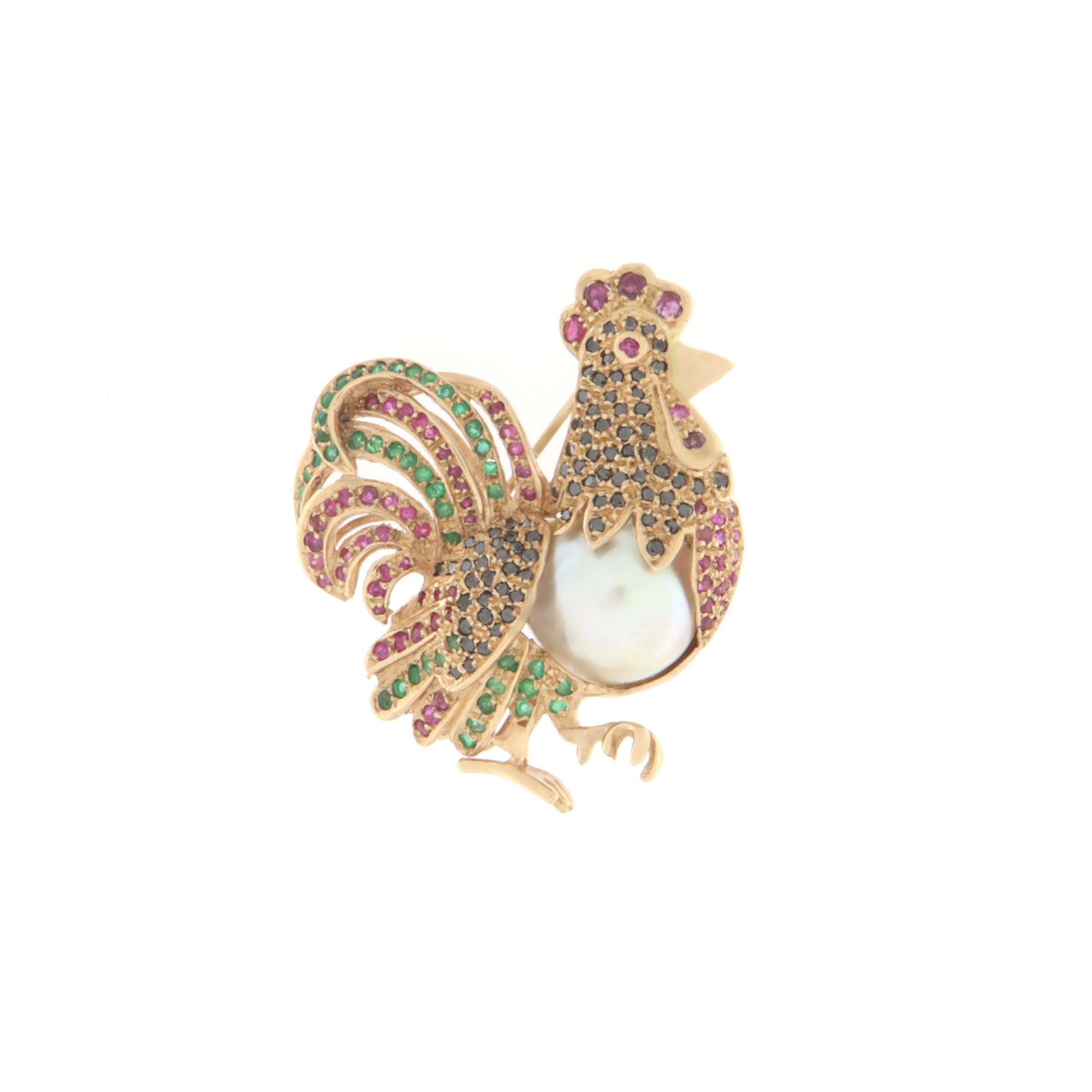 Magnificent rooster to wear for special events in 14 karat yellow gold mounted with rubies, emeralds, black diamonds and pearl

Pearl weight 5.50 grams
Emeralds and rubies weight 2.08 karat
Black Diamonds weight 0.80 karat
Brooch total weight 18.40