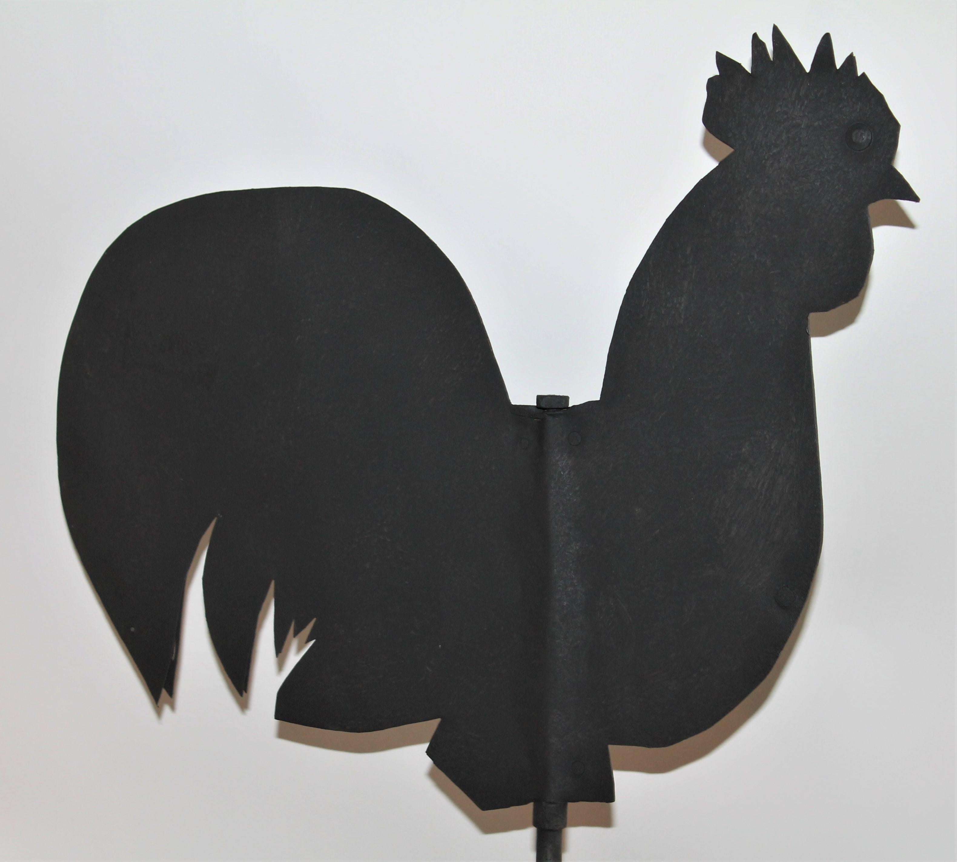 Handcrafted rooster weather vane on a wood plank base. This is a early hand cutout vane.
