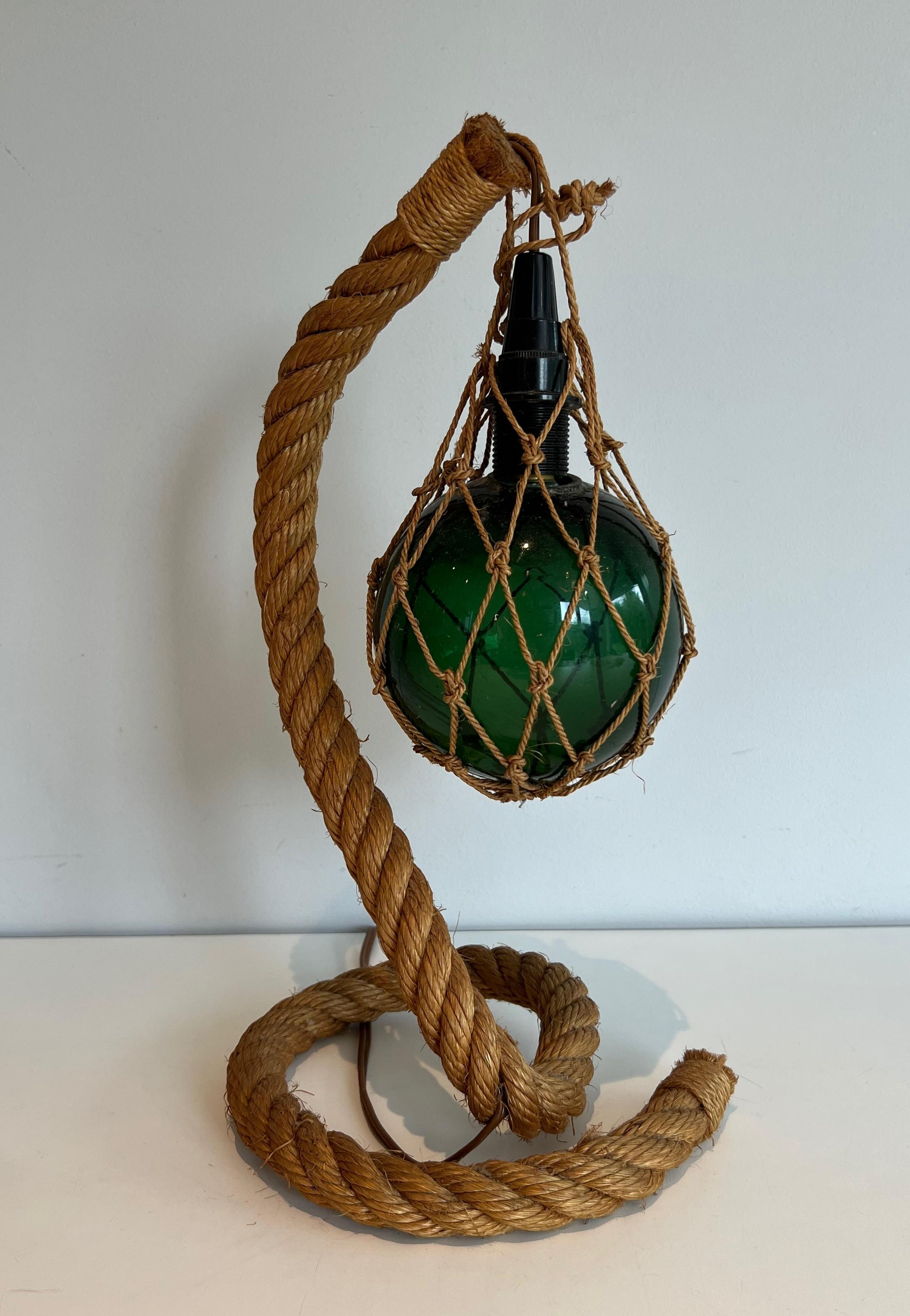 This very nice and unusual table lampe is made of rope with a green glass bowl. This is a French work by Adrien Audoux & Frida Minet (famous designers Audoux-Minet). Circa 1950