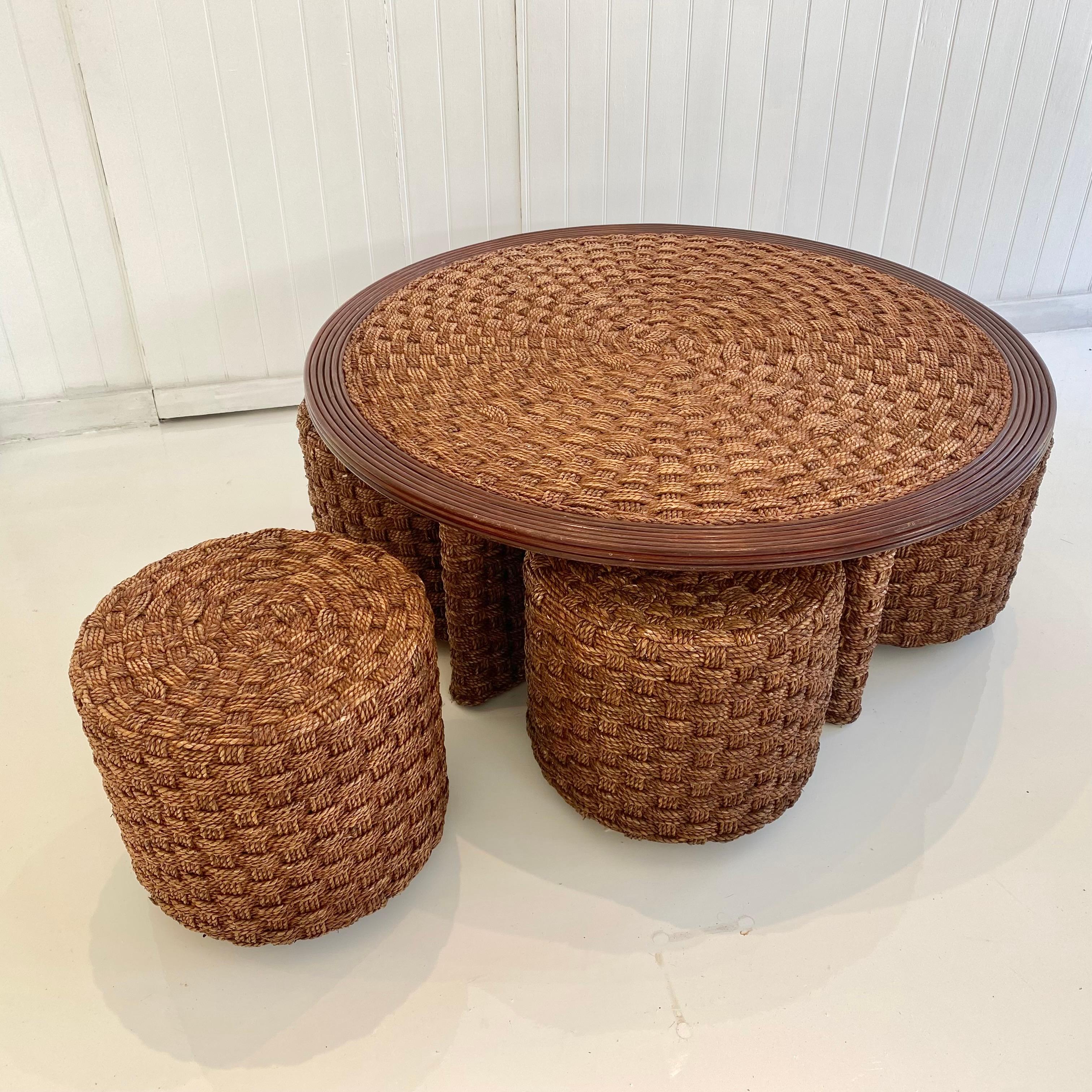 Unique rope and wood table with four matching rope stools. Perfect indoors or in a covered patio. Rope is woven flat in a criss cross pattern. Four stools tuck away neatly under table top and fit snug around the table base. Eye catching set, adding