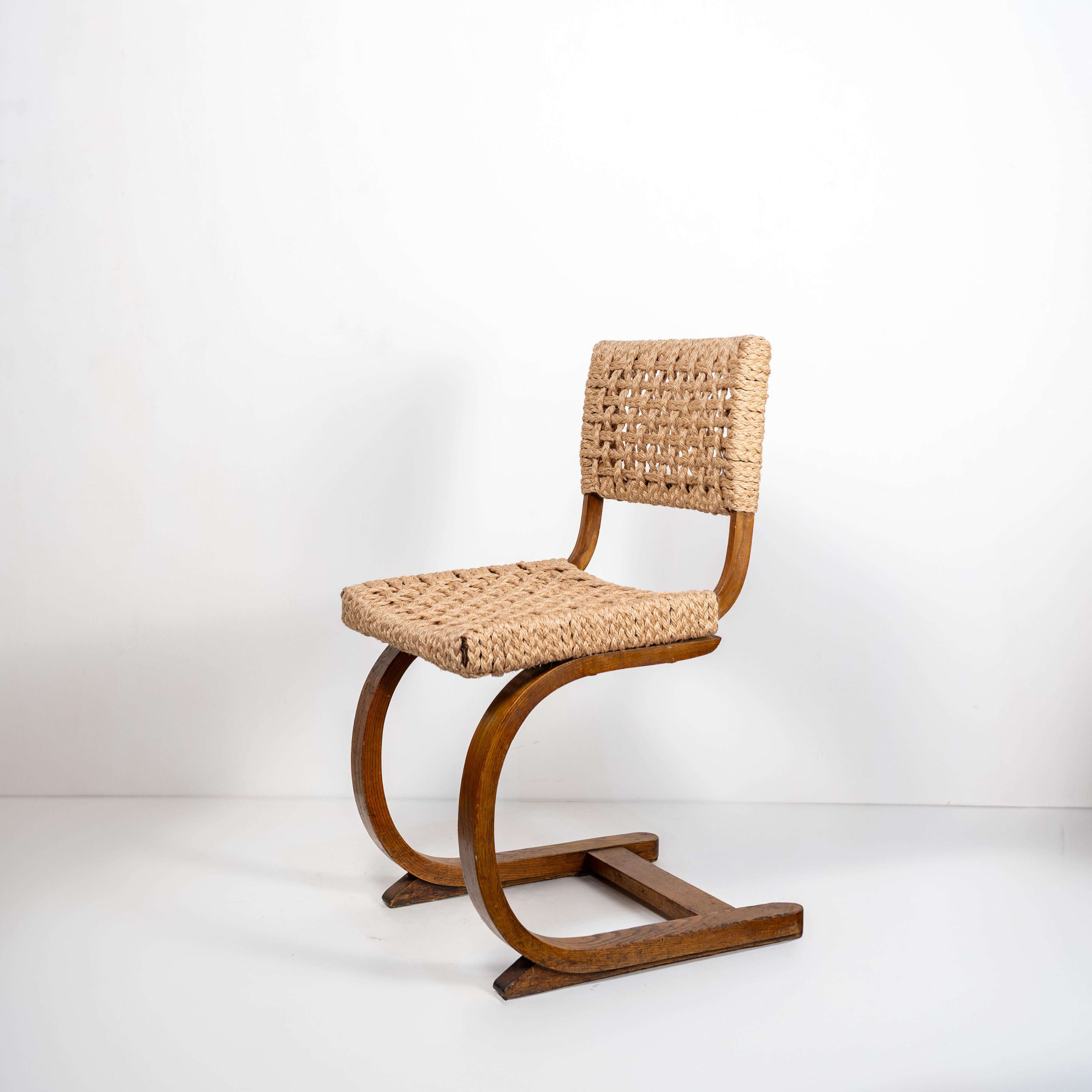 An elegant armless chair by Adrien Audoux and Frida Minet for Vibo Vesoul, crafted in wood with a handwoven natural rope seat and backrest. The distinctive curved frame and tactile woven surface embody the duo’s signature blend of organic materials