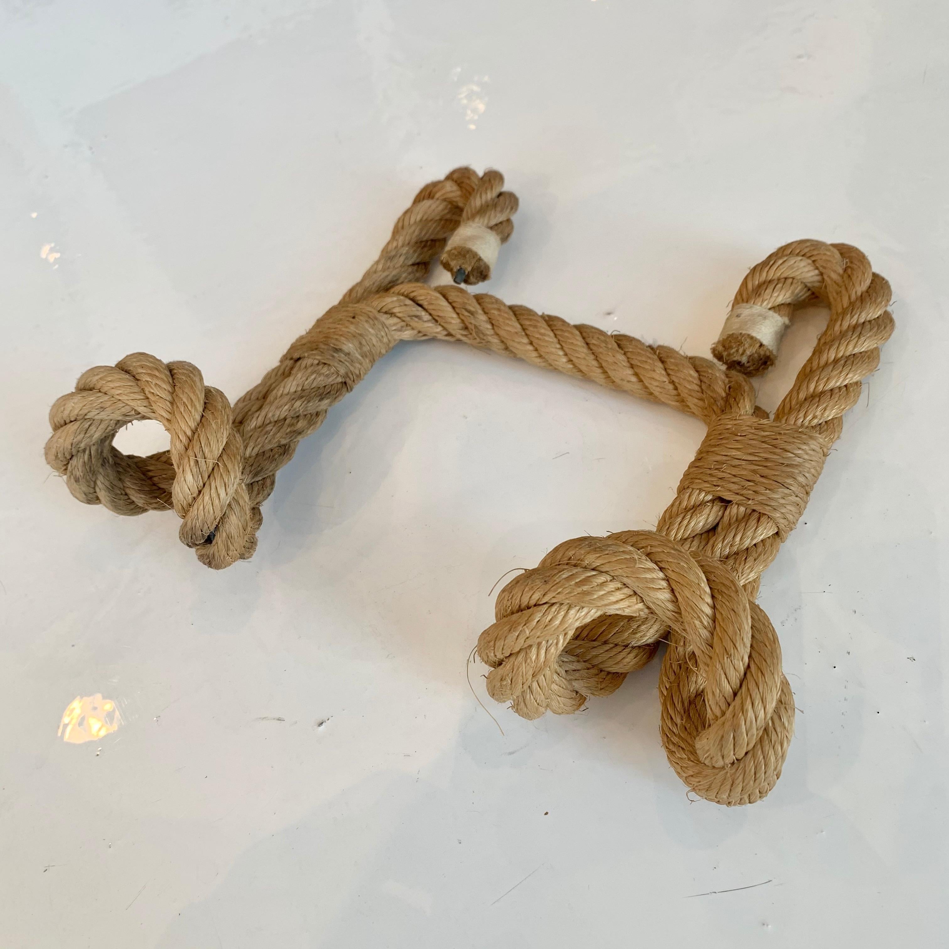 Handsome rope coat rack by Audoux and Minet. Completely wrapped in rope and held together by twine. Three tongue hooks with double strand of rope throughout. Great looking wall item. Good vintage condition with very minor wear. Perfect for hats or