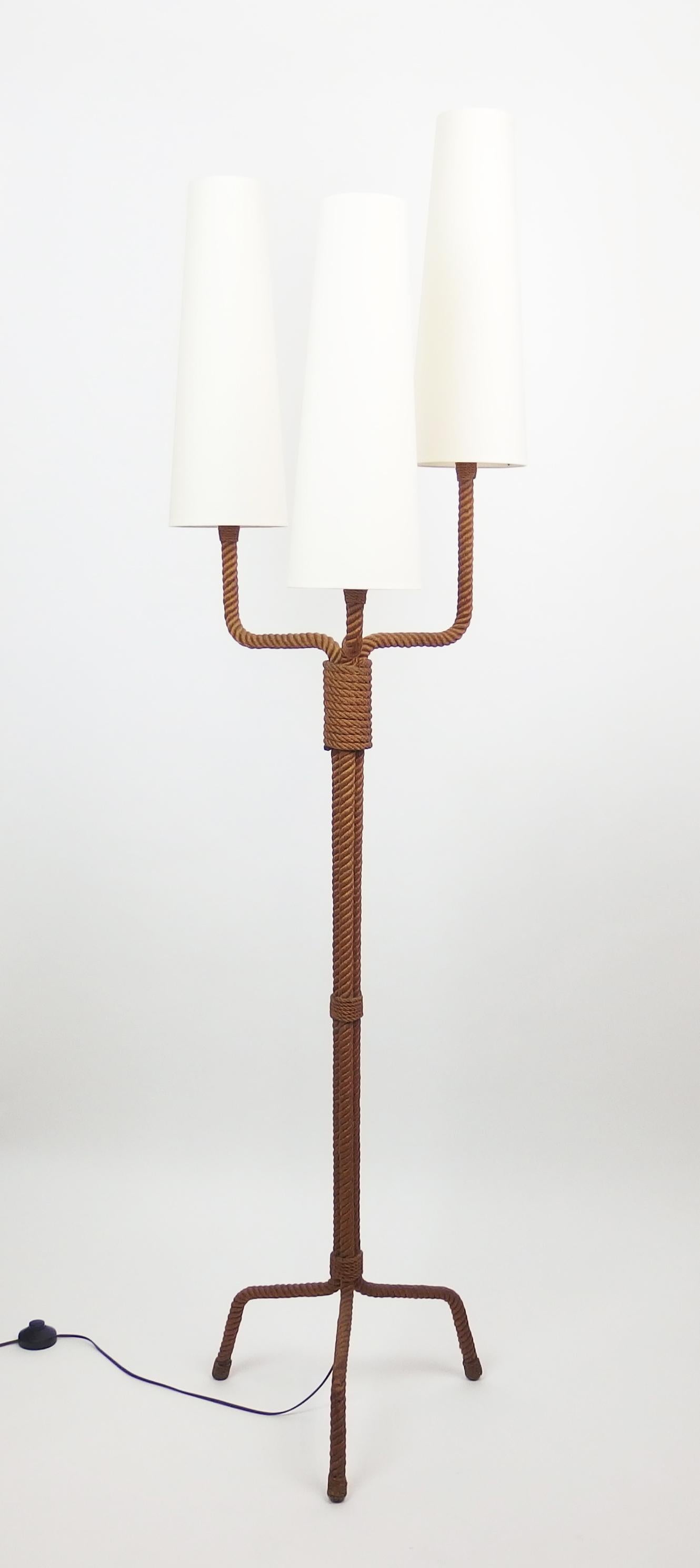 A three arms, tobacco color stained, rope floor lamp by Audoux Minet. New shades. American sockets.
Measures: Higher arm with shade 70.80 in
Lower arm with shade 65 in.