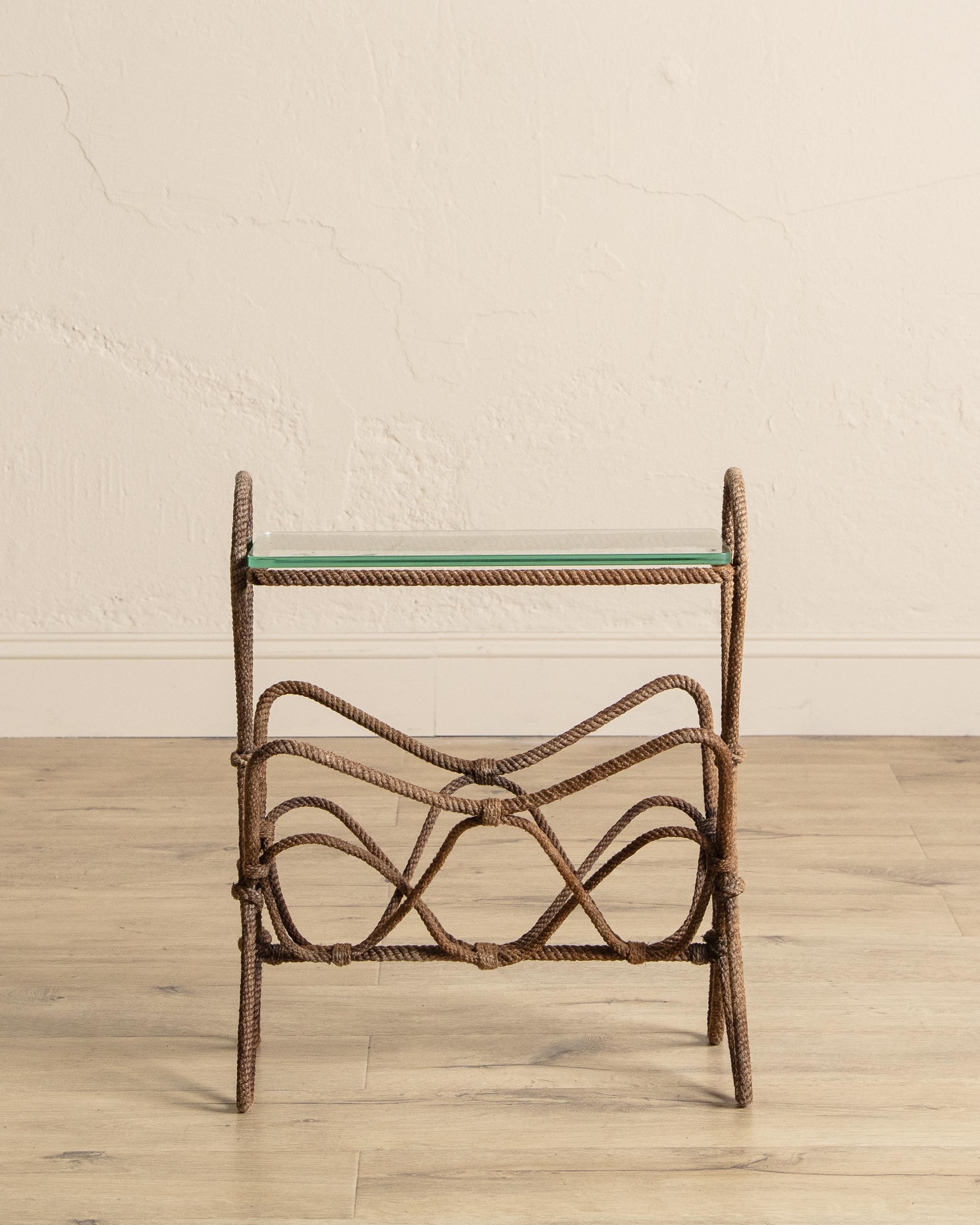 This sculptural magazine rack combines functional design with artistic craftsmanship, featuring a hand-tied knotted rope frame that exudes rustic charm and organic appeal. The intricate ropework creates a sense of movement and texture, offering a