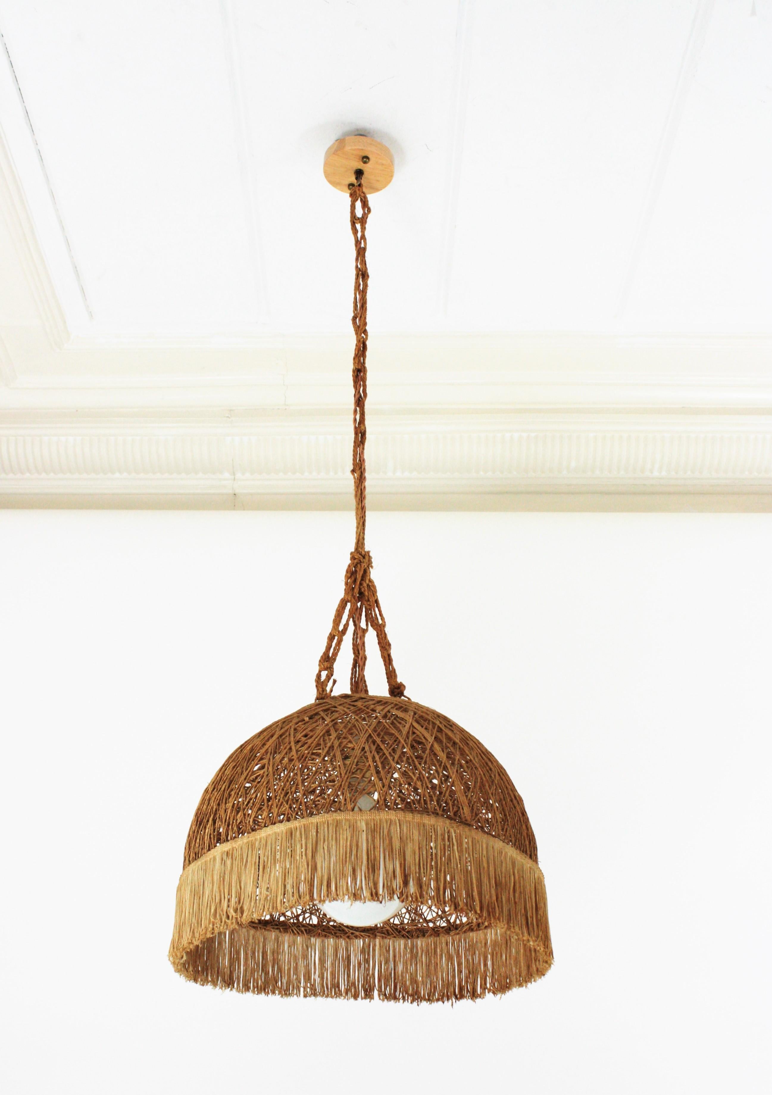 Dome Shaped Pendant Hanging Light, Rope, Jute, Fringe. Spain, 1960s
Rare suspension with hand-woven cord semi-sphere lampshade hanging from a rope chain and topped by a woden canopy.
Place it hanging over a kitchen's table or dining area on in any