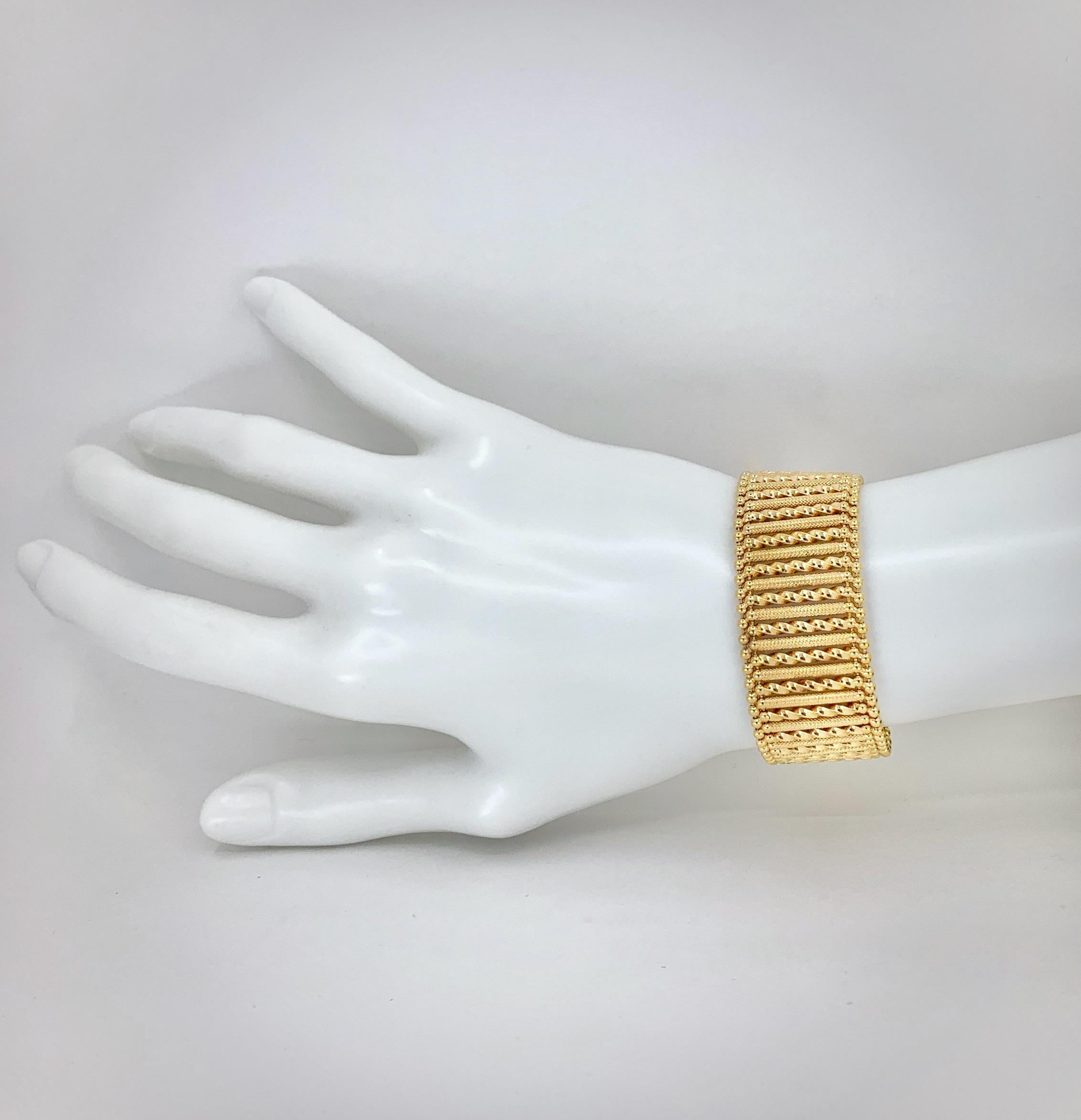 Narrow columns of richly hued 18 karat gold, in alternating twisty and textured patterns, are strung between edges finished with UnoAErre's signature ball beads.  The end result is comfortable like a chain bracelet but has the sexier bold look of a