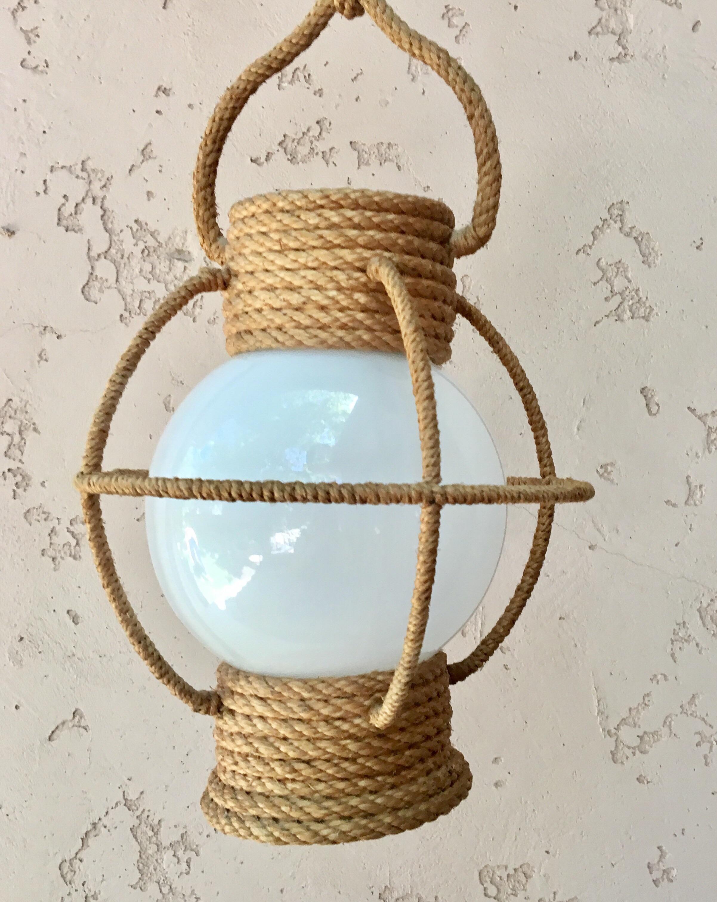 Lustre lanterne circulaire en corde Audoux Minet, circa 1960 avec verre opalin blanc.
Mesures : Hauteur / 10.5