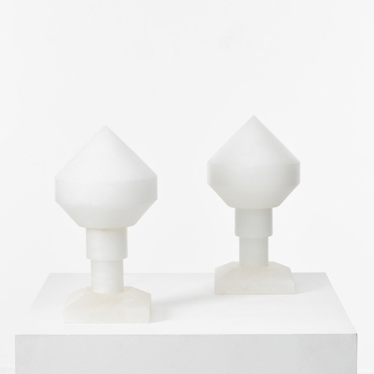 A pair of ‘Zeleste’ alabaster table lamps designed by Santiago Roqueta and Angel Jové. These lamps are a rare first edition example distinctive for their beautifully considered form that has been carved from alabaster stone. The conical shade is