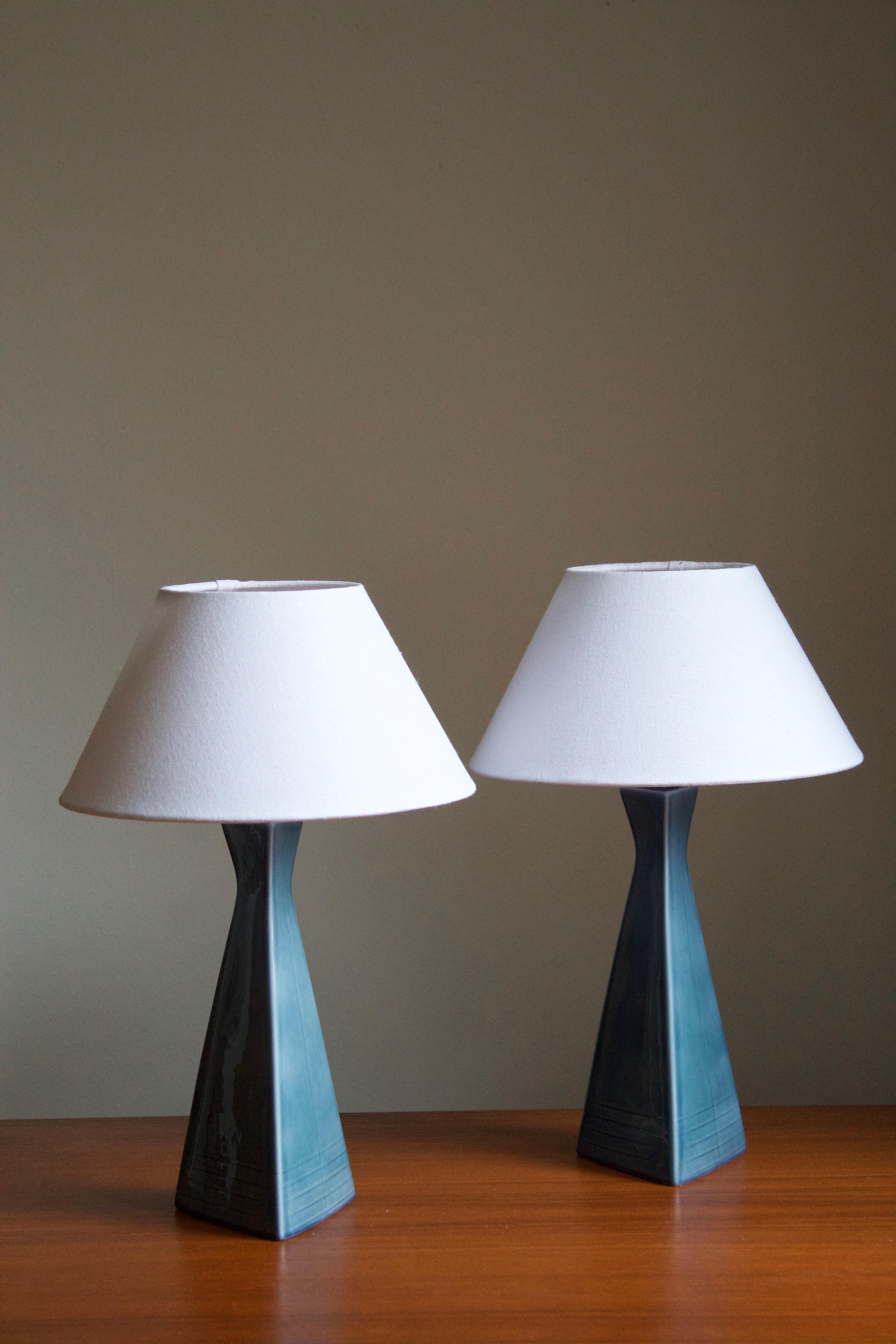 A pair of table lamps produced by Rörstand, Sweden, c. 1950s. Stamped. Base in blue glazed ceramic with simple incised ornamentation. Sold without lampshades.