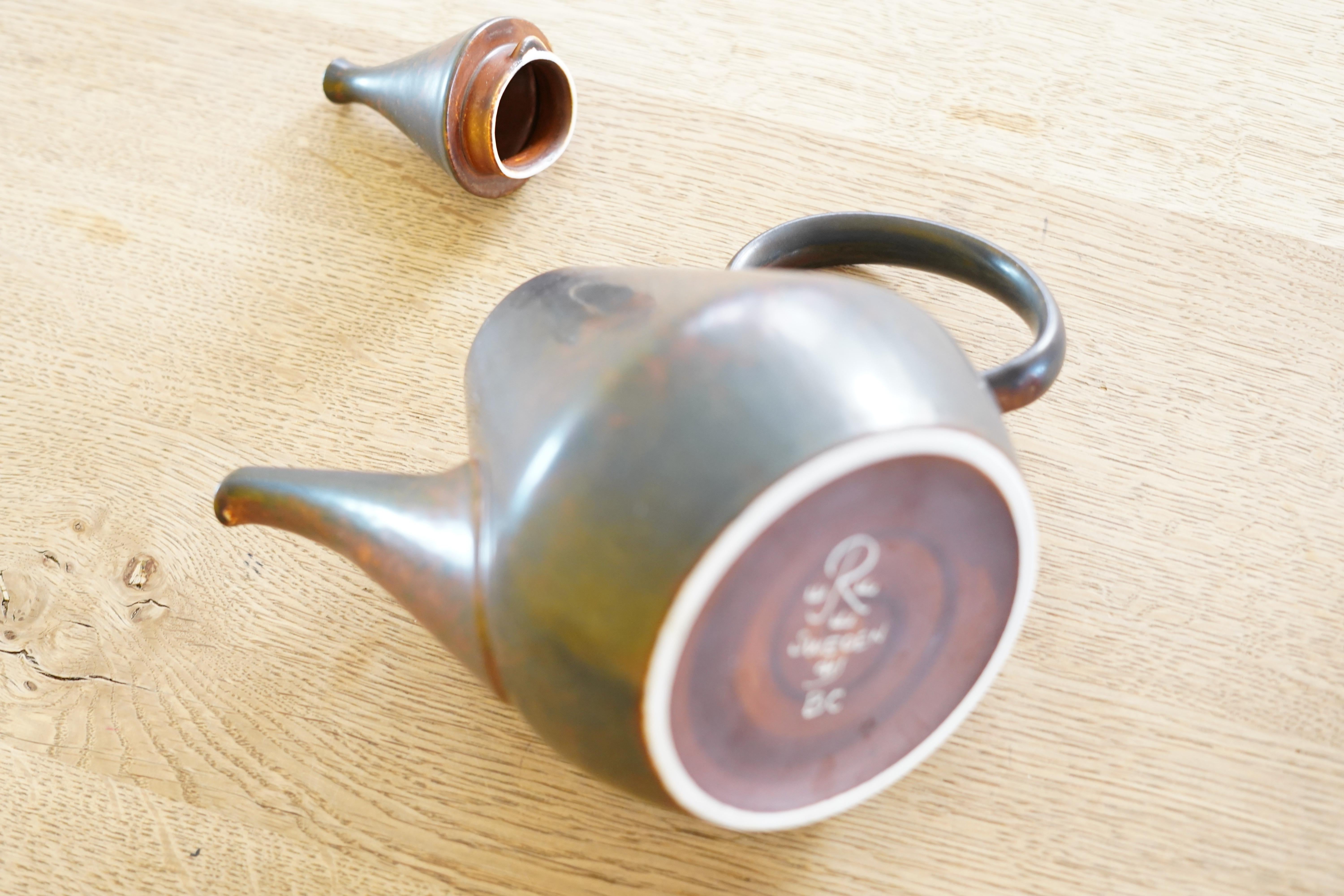 Carl-Harry Stålhane Rörstrand tea pot Sweden, 1960.
Simple beauty that shows its colors in the glaze depending on the light almost matte dusty ash black with rust red pattern.

