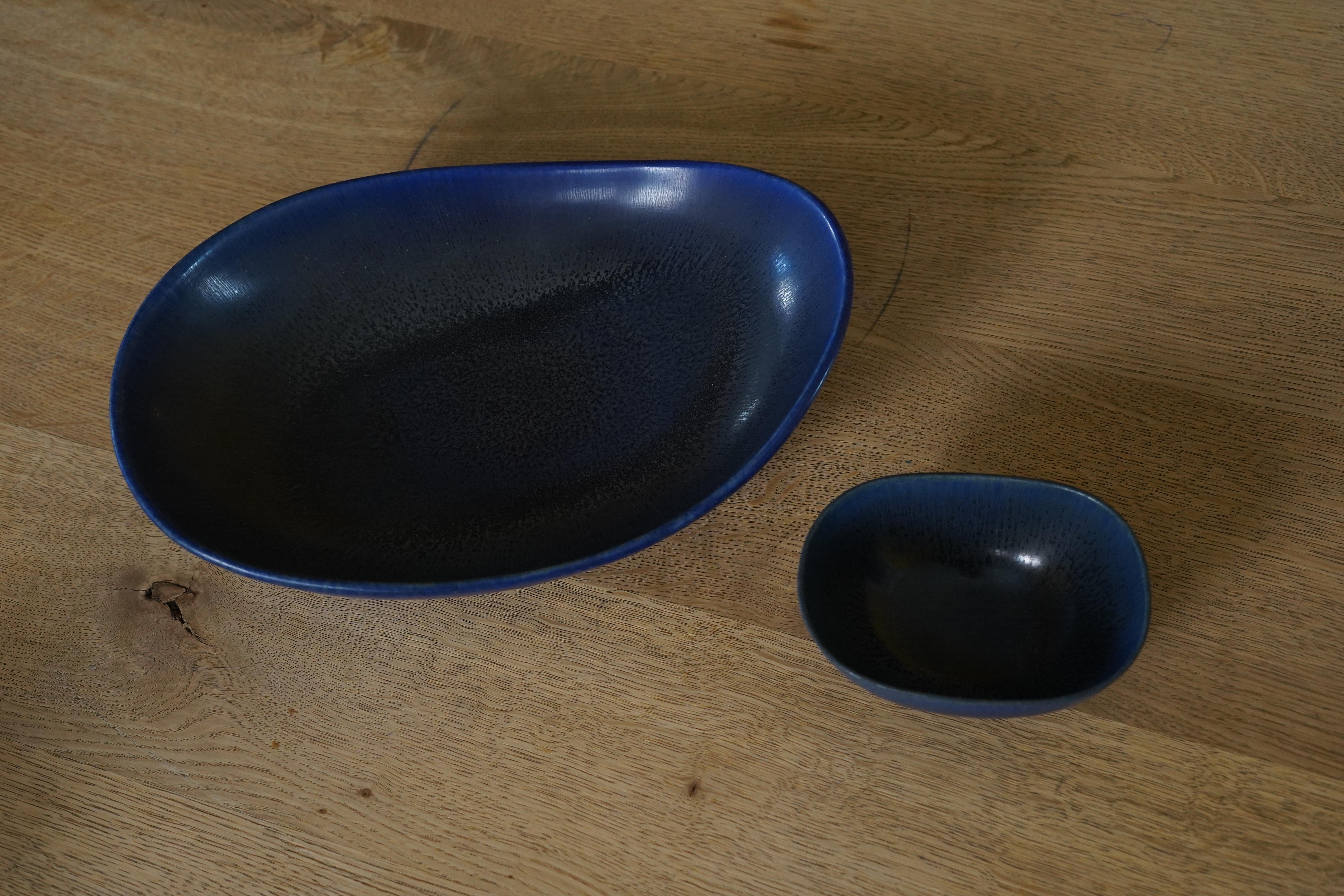 Carl-Harry Stålhane pour Rörstrand  plateaux en céramique bleu foncé Suède, 1960.
Ensemble plateau et bol grand plateau plat en céramique bleu foncé aux côtés arrondis et petit plateau assorti.
Grand plateau 11