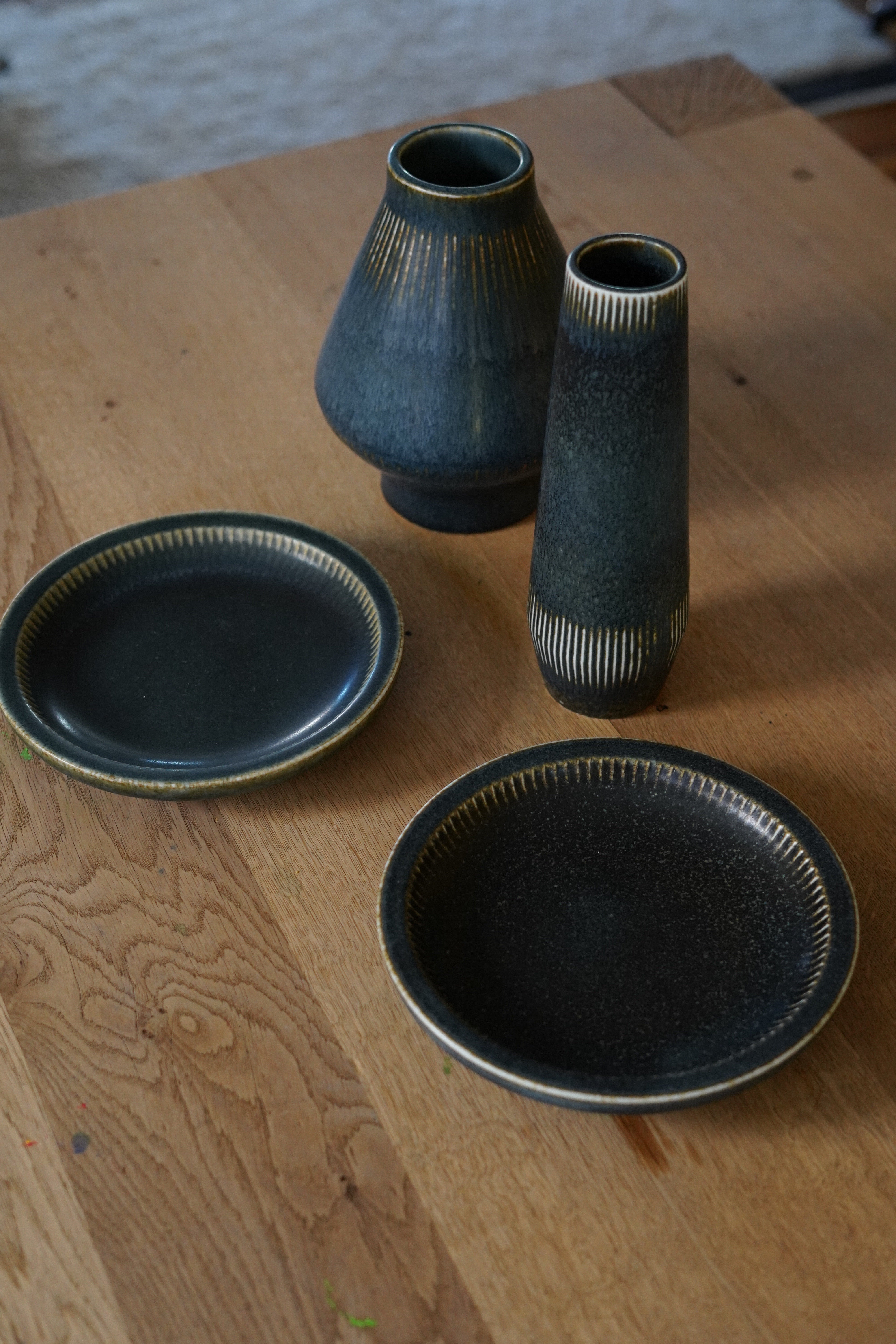 Carl-Harry Stålhane für Rörstrand  dunkelblaue Keramikschalen Schweden, 1960.
Set aus zwei Tabletts und zwei Vasen in blau/grauer Glasur
Vasen 9,5