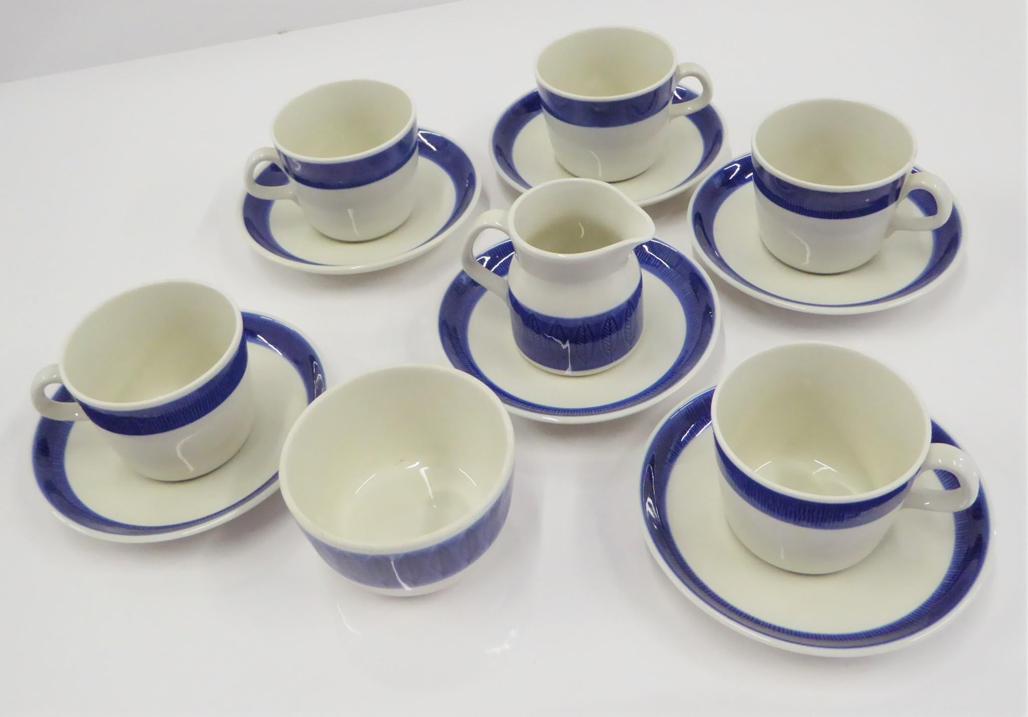 A Rörstrand coffee / tea set of cups, saucers, creamer and sugar bowl in the  KOKA BLÅ  pattern designed by Hertha Bengtson, was first manufactured in 1956 and remained in production until 1988.  The translation of the name is Boil/ Scald Blue which