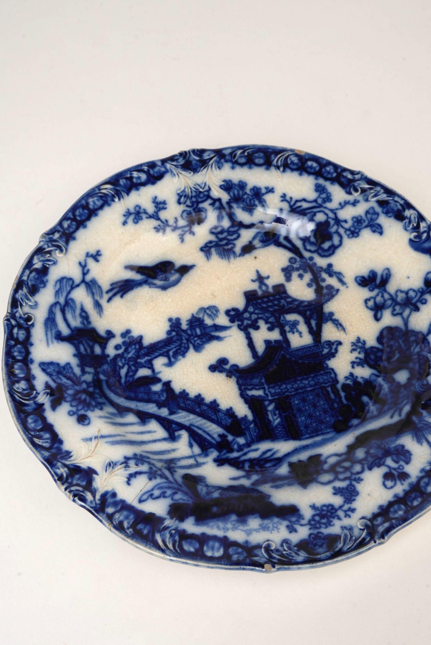 A rare and richly detailed blue and white earthenware plate by esteemed Swedish porcelain maker Rörstrand, dating to the mid-1800s. Crafted using the classic transferware technique, this plate showcases an exquisite chinoiserie-style pagoda scene,