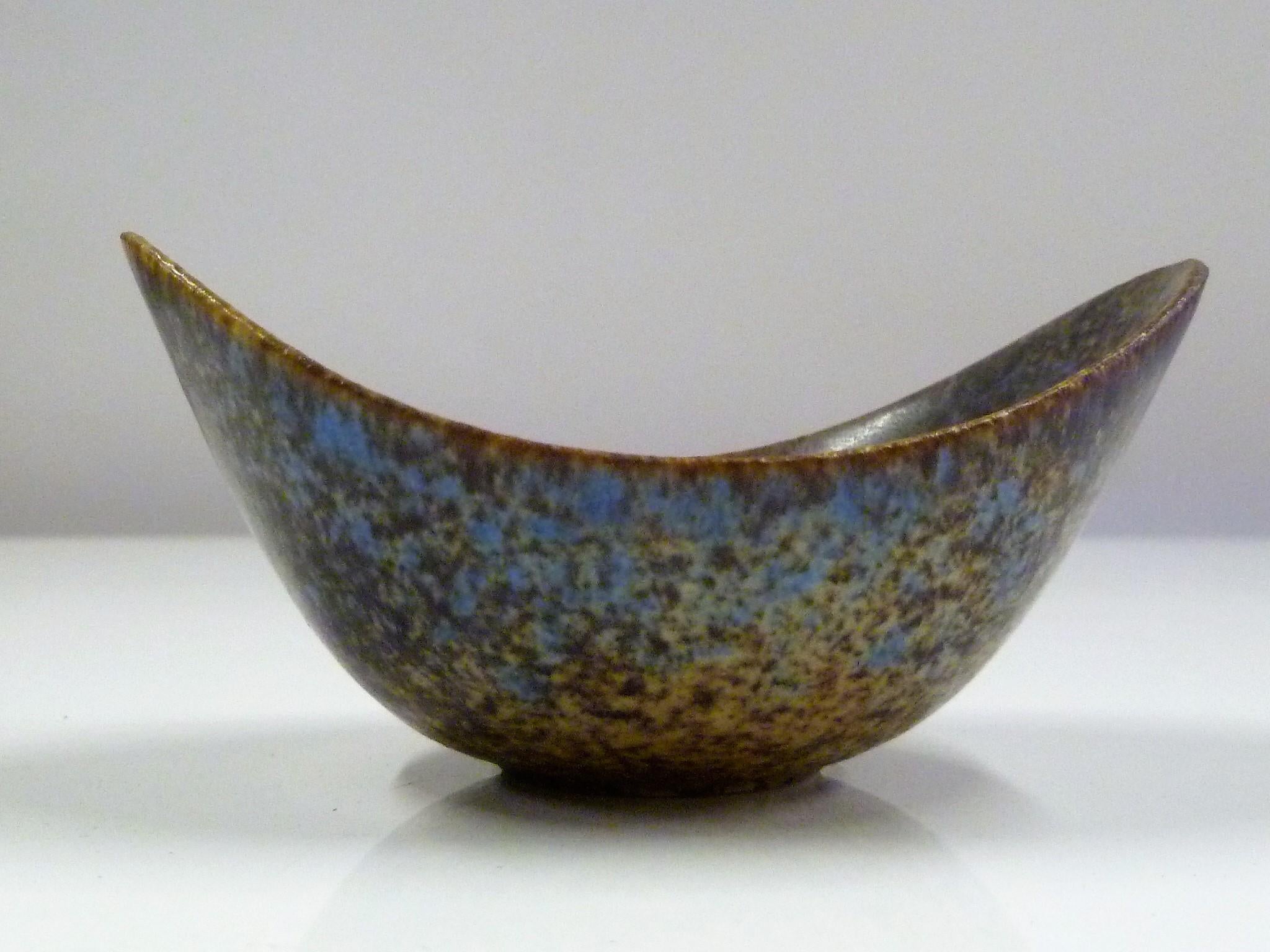Created by Gunnard Nylund for Rorstrand, Sweden, Mid-Century Modern stoneware vessel with upturn edges. Beautiful mottled glaze in brown, blue, purple and beige colors.
Measurements: 4 in. wide, 3 in. deep, 1 in. high in center and 1 1/2 in. high