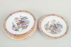 Rörstrand. Set di nove piatti da pranzo in maiolica. Serie 'Giappone'. Inizio del XX secolo.