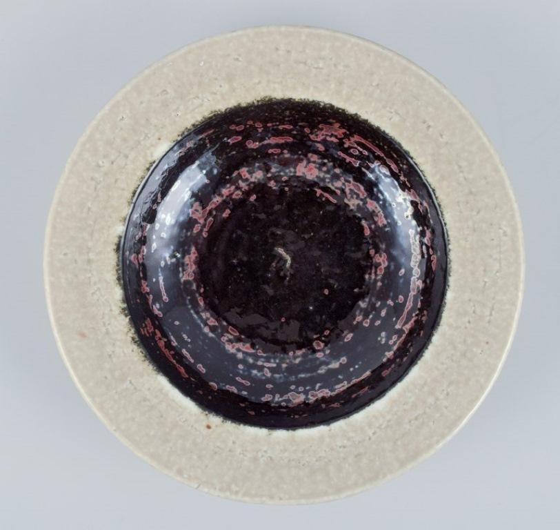 Scandinavian Modern Rörstrand, Sweden, ceramic bowl in cream and black metallic glaze. For Sale
