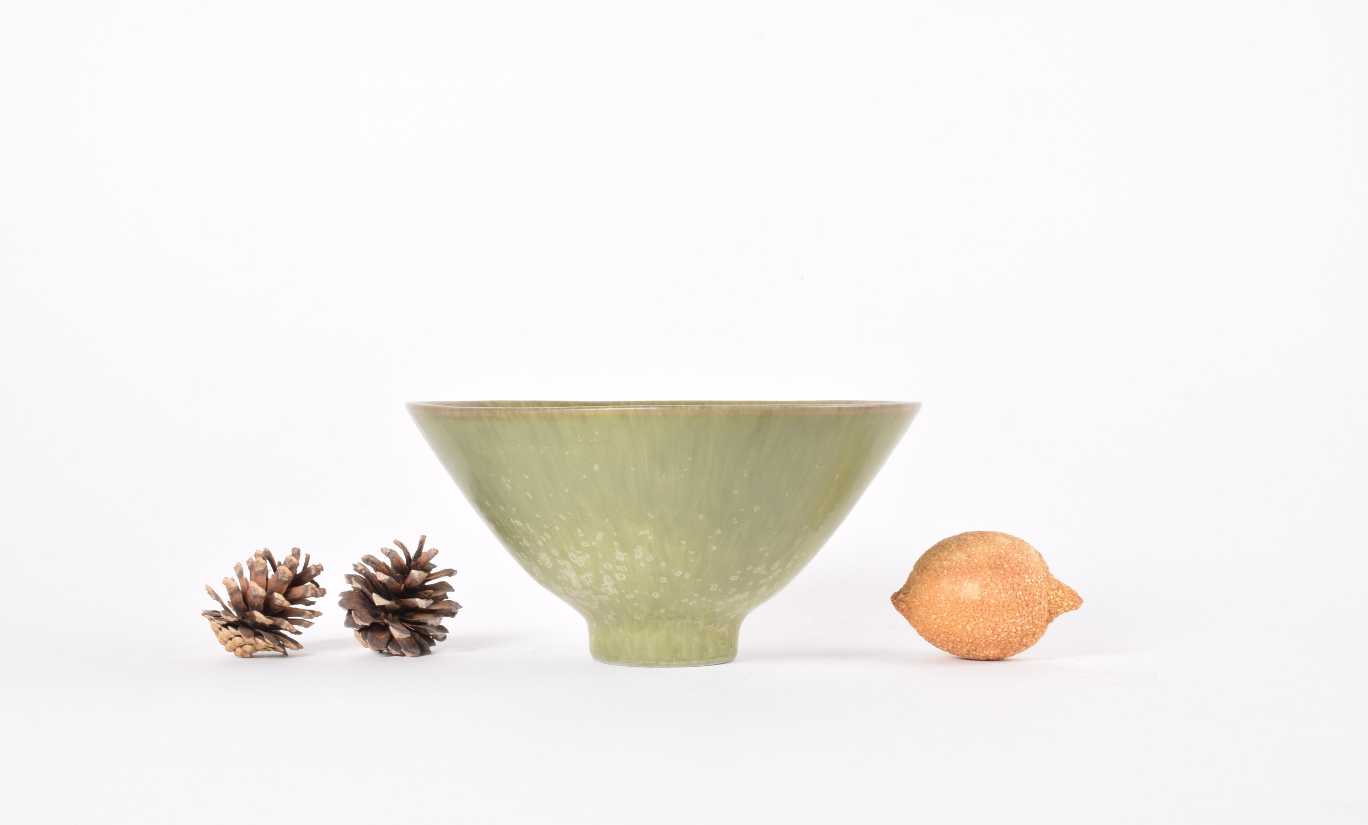 Cuenco con pie vintage del ceramista sueco Carl-Harry Stålhane para Rörstrand Sweden. Fabricado hacia la década de 1950.

El cuenco es de gres y tiene una forma ligeramente triangular. Está decorada con un m interesante vidriado moteado de verde.