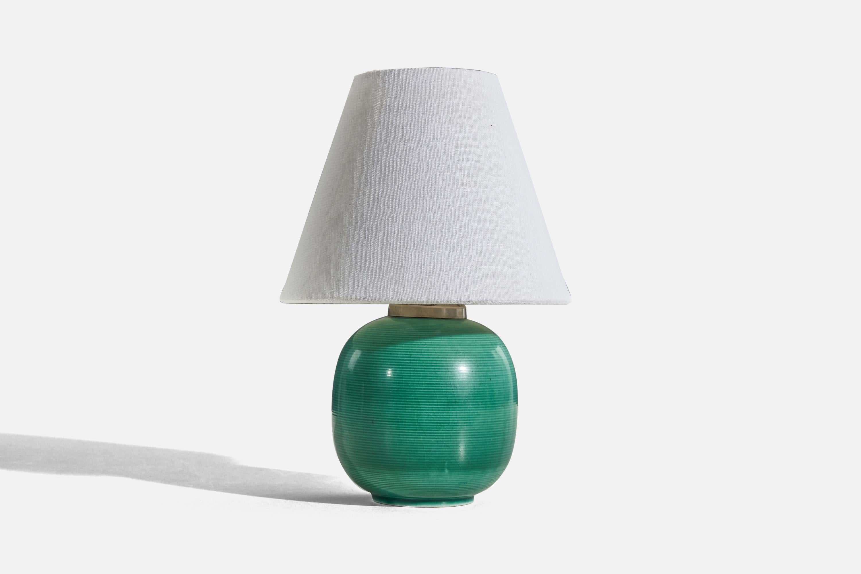 A green, glazed stoneware table lamp designed and produced by Rörstrand, Sweden, 1940s. 

Sold without lampshade. 
Dimensions of Lamp (inches) : 8.75 x 5.25 x 5.25 (H x W x D)
Dimensions of Shade (inches) : 4 x 8 x 6.5 (T x B x S)
Dimension of