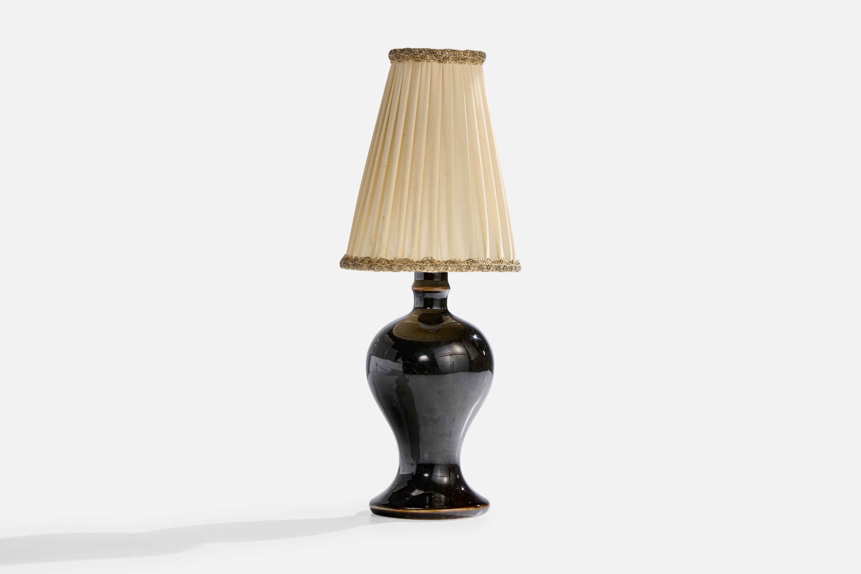 A black-glazed stoneware and beige fabric table lamp designed and produced by Rörstrand, Sweden, c. 1940s.

Dimensions of Lamp with Shade (inches): 12.25