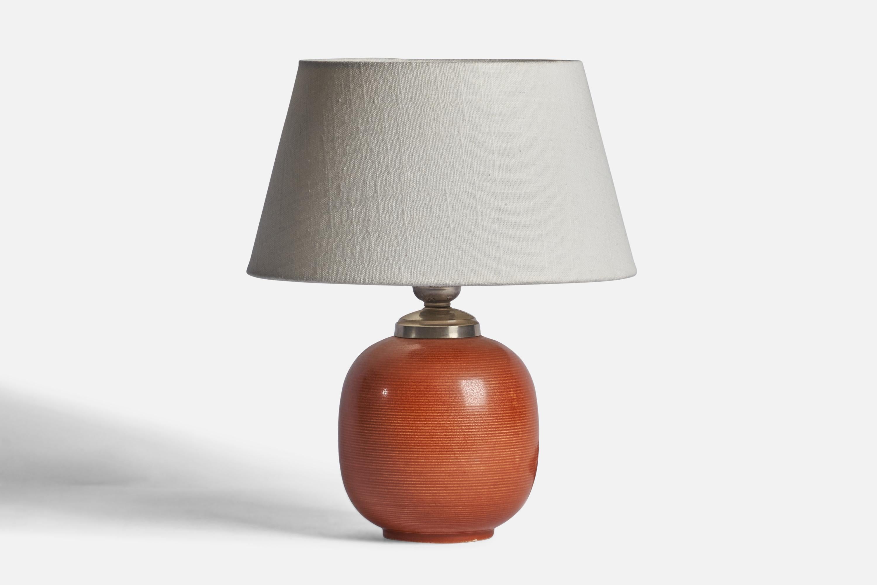 A red-glazed fluted stoneware and metal table lamp designed and produced by Rörstrand, Sweden, 1930s.

Dimensions of Lamp (inches): 9.25” H x 5” Diameter
Dimensions of Shade (inches): 7” Top Diameter x 10” Bottom Diameter x 5.5” H 
Dimensions of