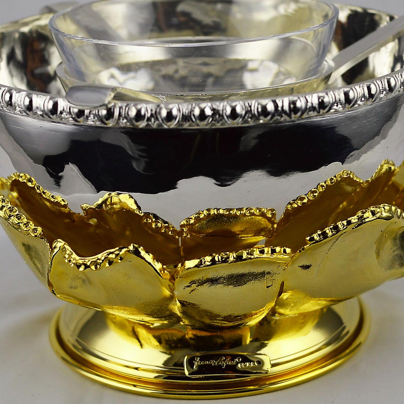 Just like the petals of a rare flower that open to receive the warm glow of the sun, this superb caviar bowl boasts a series of elements that raise up from its elongated base, creating soft curls and elegant curves. Resting on an oval base, this