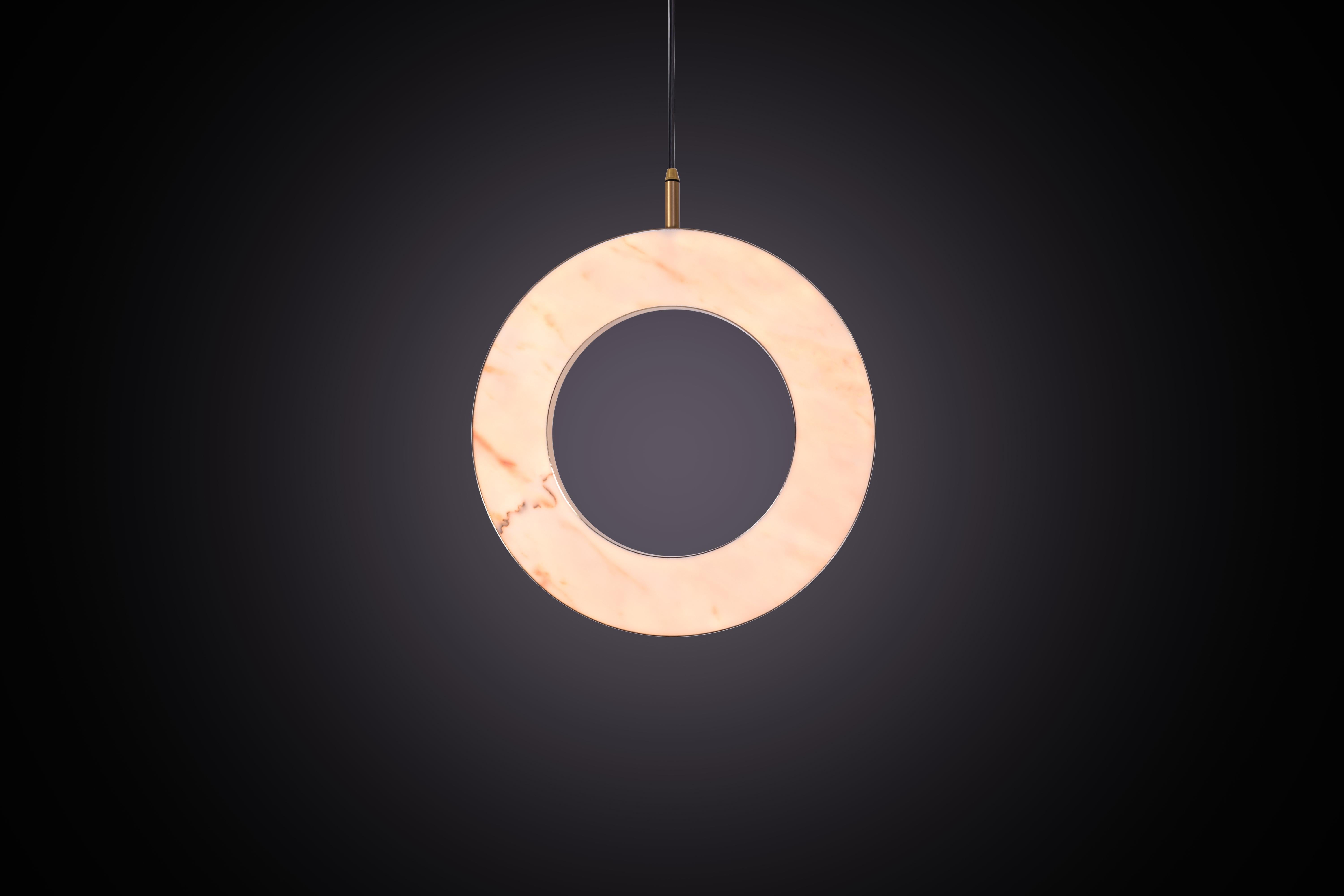 La collezione Rosa Rings è stata progettata per mostrare la bellezza opaca del marmo naturale. Il pendente incorpora un disco di marmo Rosa Estremoz retroilluminato che emette un'illuminazione morbida e calda, attraversata dalle venature naturali