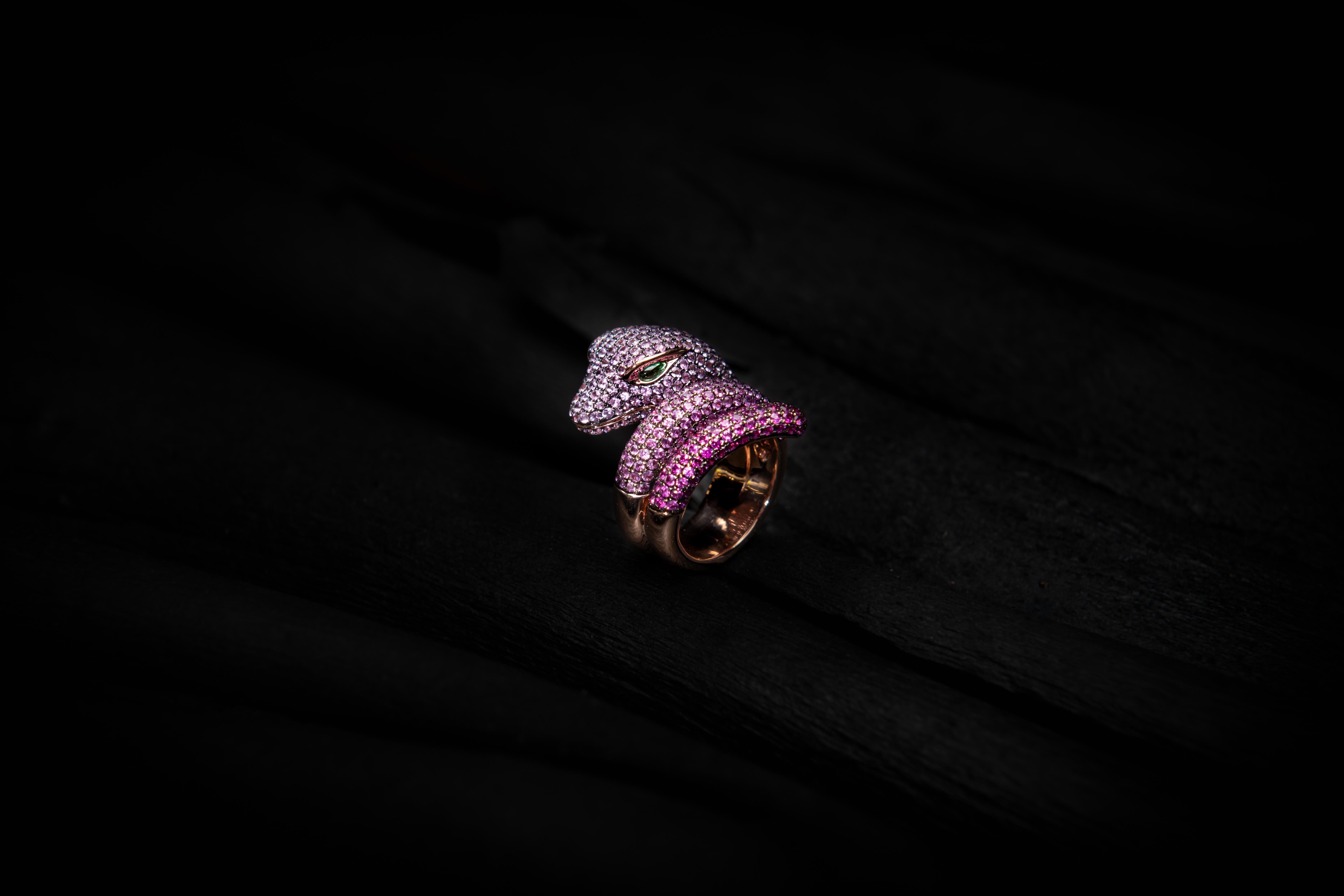 Anaconda snake shaped ring in 18 Karat rose and black Gold with a gradient of 6.39 Carat pink Sapphires on body and cabochon cut 0.17 Carat Emerald eyes.
To request additional photos or videos, please contact us.
One in stock available, size 7.
No