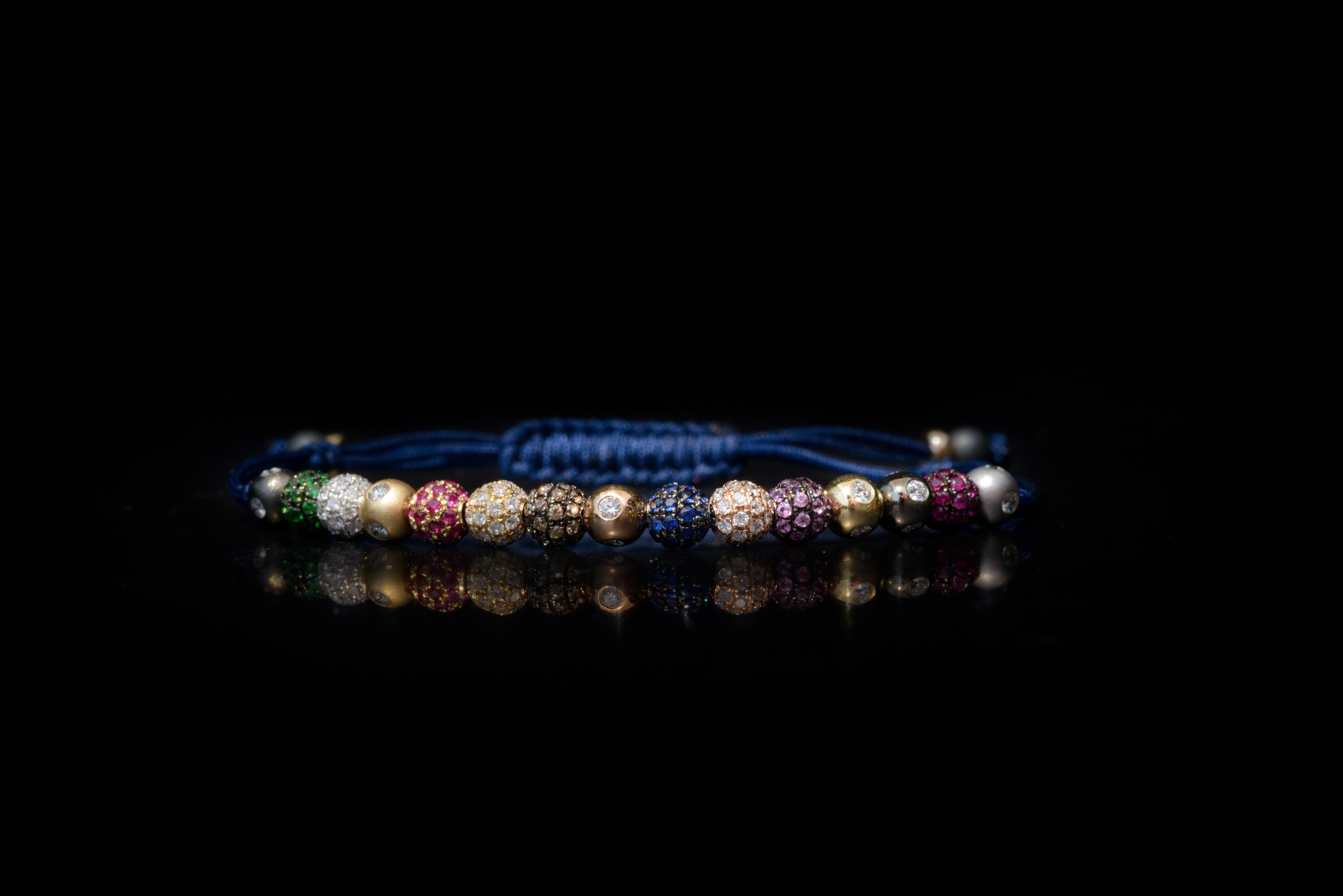 A bracelet made of a medley of fifteen 5mm pavé beads in 18 Karat yellow, white, black and rose Gold, with white and brown Diamonds, Rubies, Tsavorites, blue and pink Sapphires, in macramé (Ref. B.3)
Carat weight: White Diamond .48 CT / Ruby 1.09 CT