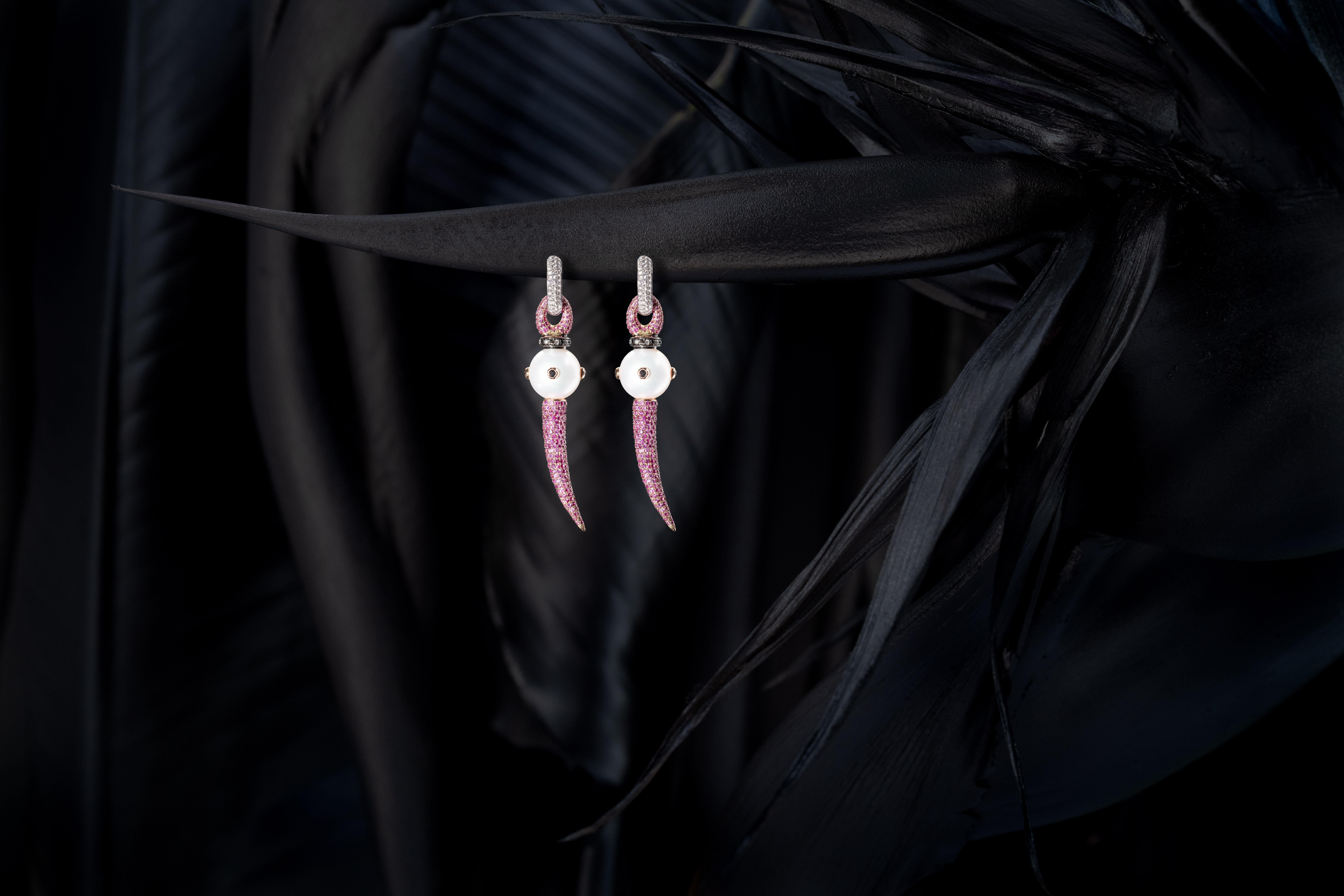 12.7 mm Australian South Sea Pearls (AAA quality) with encrusted black Diamonds in 18k yellow Gold, with pavé horns and sliders in 18k black Gold & 5.2 Carat pink Sapphires. 
Shown on 18k white Gold and 0.58 Carat white Diamond hoops. 
One pair in