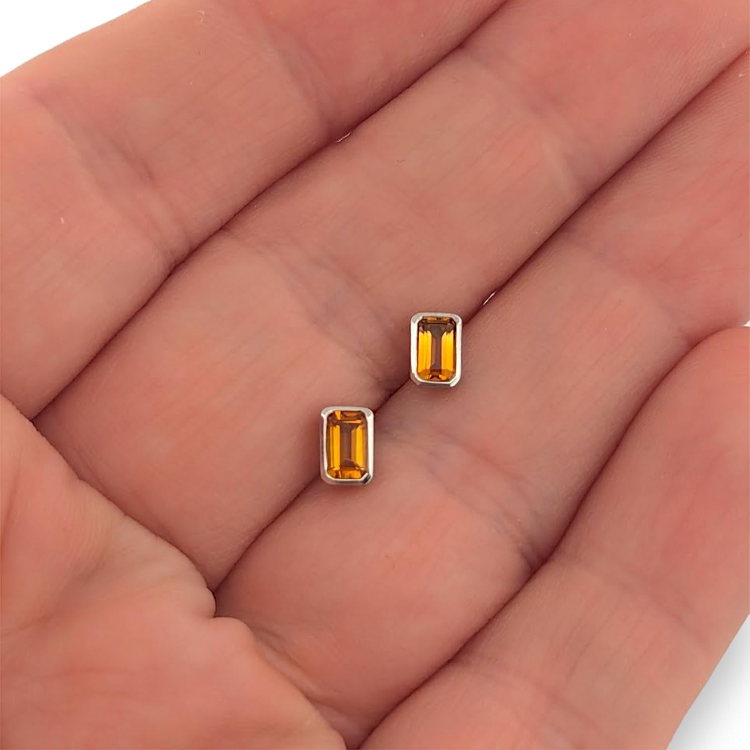 Die Rosamund-Ohrringe sind ein strahlender Ausdruck von schlichter Eleganz. Diese minimalistischen Ohrstecker aus raffiniertem 10-karätigem Weißgold sind mit 0,53 Karat natürlichen Zitrinen im Smaragdschliff in sauberen Lünettenfassungen gefertigt