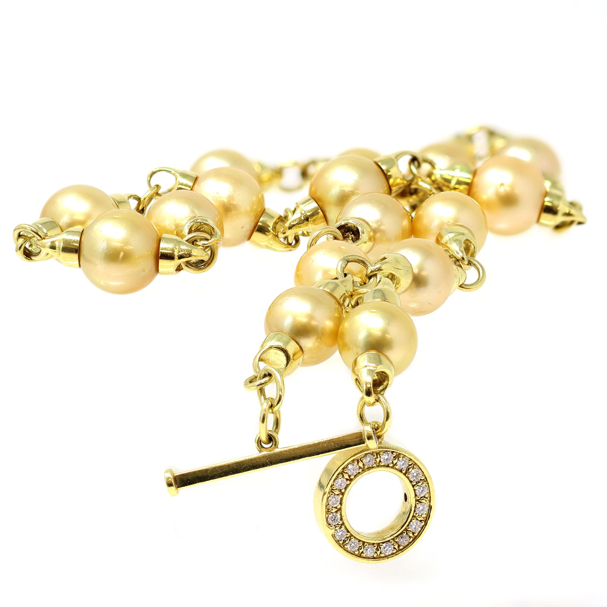 A contemporary natural gold South Sea pearl station necklace in 18K yellow gold with a diamond toggle clasp. Designed by Rosaria Varra, this station necklace features 11-12mm natural gold South Sea pearls with very good luster and few surface