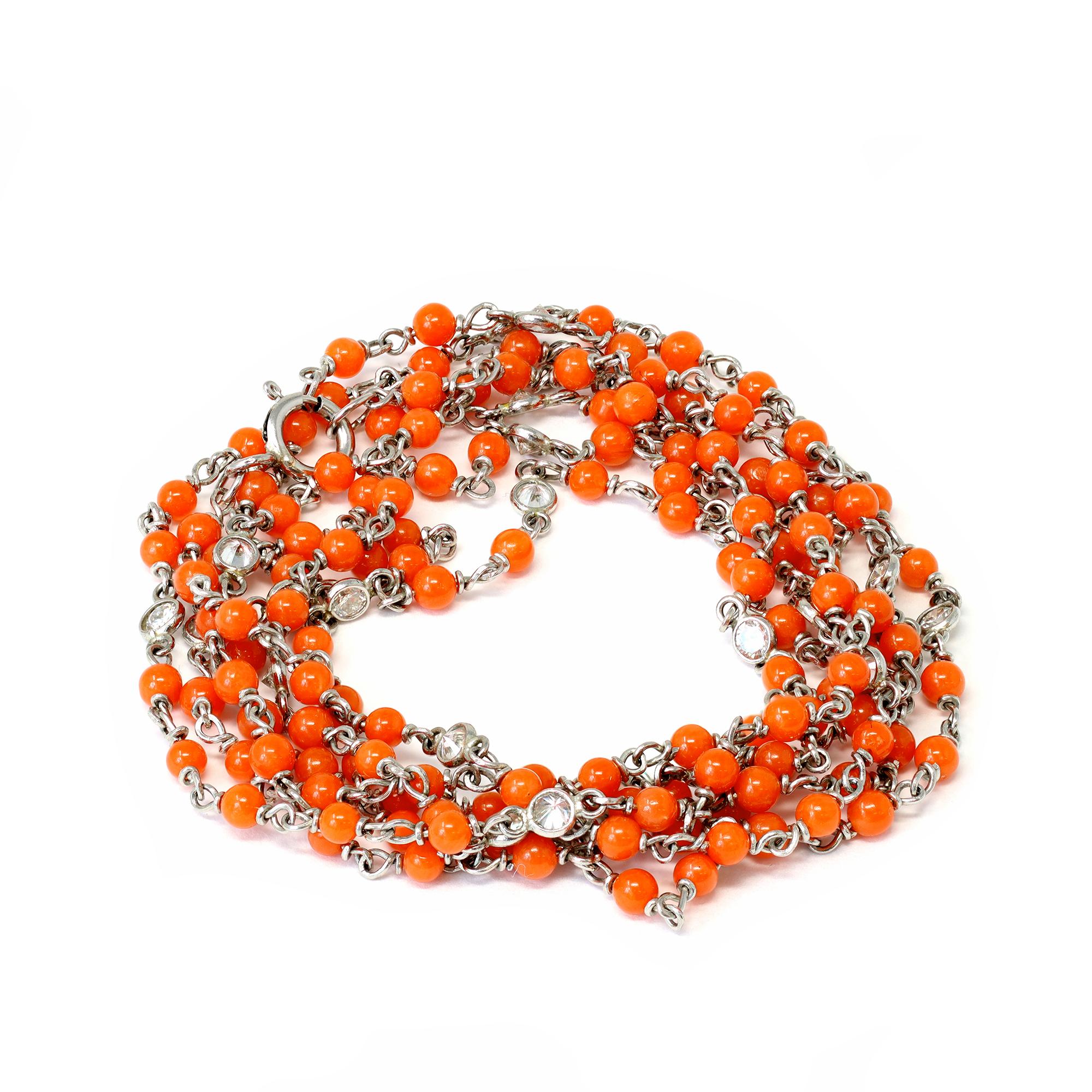 A dainty handmade opera necklace designed by Rosaria Varra, featuring natural sardinian coral beads alternating with bezel set round diamonds. The necklace is created in platinum and has an estimated diamond weight of 0.87 carats, G color, VS-SI