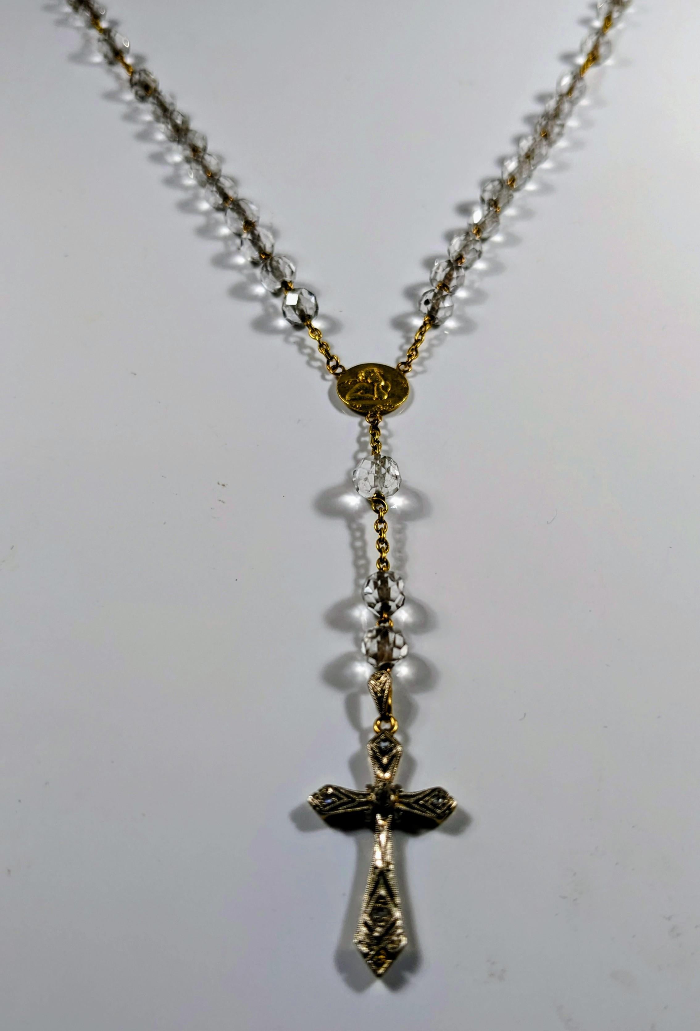 Rosary in yellow gold with faceted crystal beads, a medal with an angel and an openwork cross in gold with diamonds, on views of white gold
 Length to the medal: 60 cm. From the medal to the cross: 1o cm.
 It weight is 23,3 grams.

 All PRADERA
