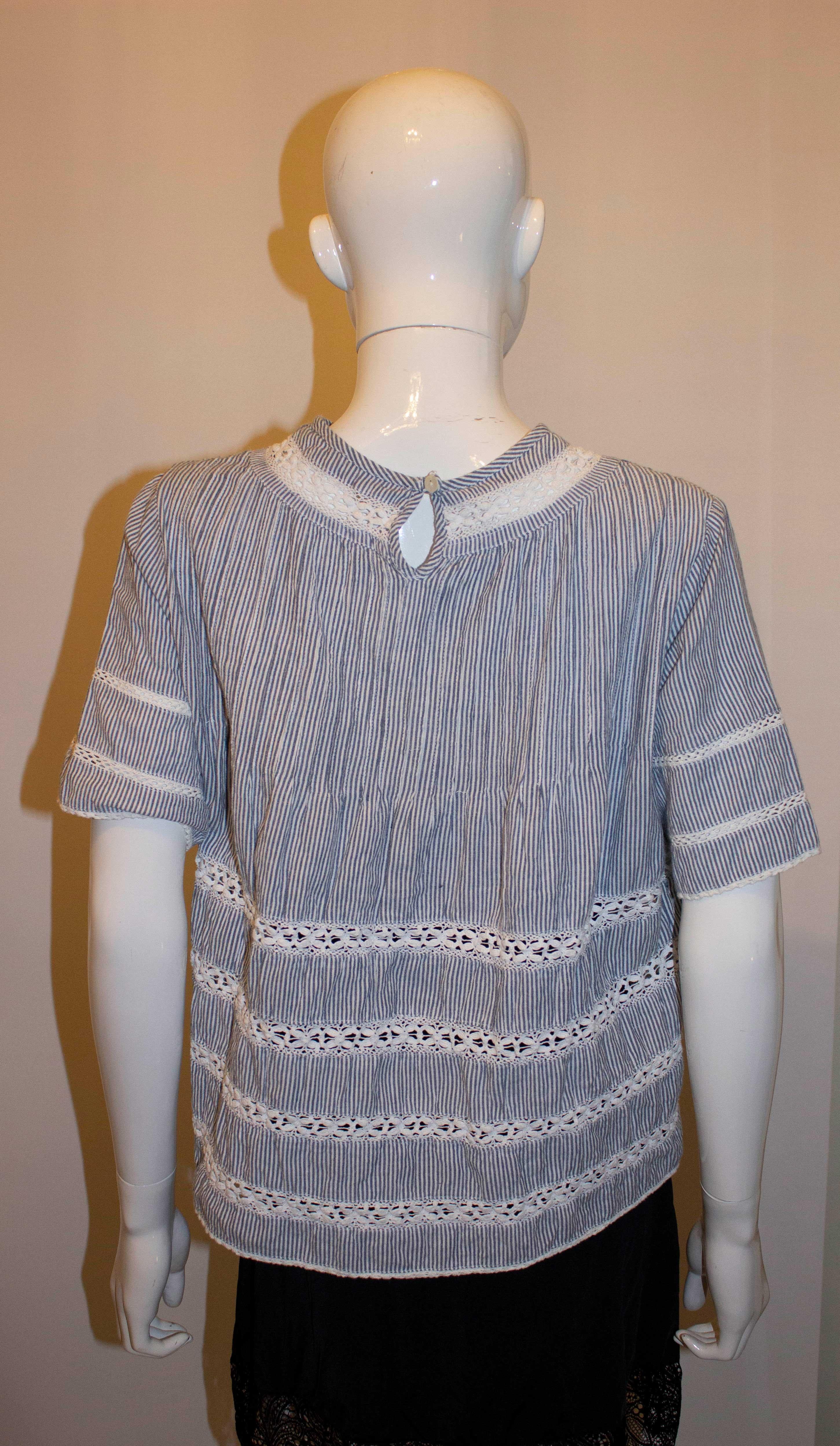 A pretty cotton top by Rose and Rose perfect for Spring / Summer days. The cotton top is in a blue and white stripe with lace detail and pintucks on the front.  It has a button opening at the back.
Size M  Bustup to 38'', length 21''