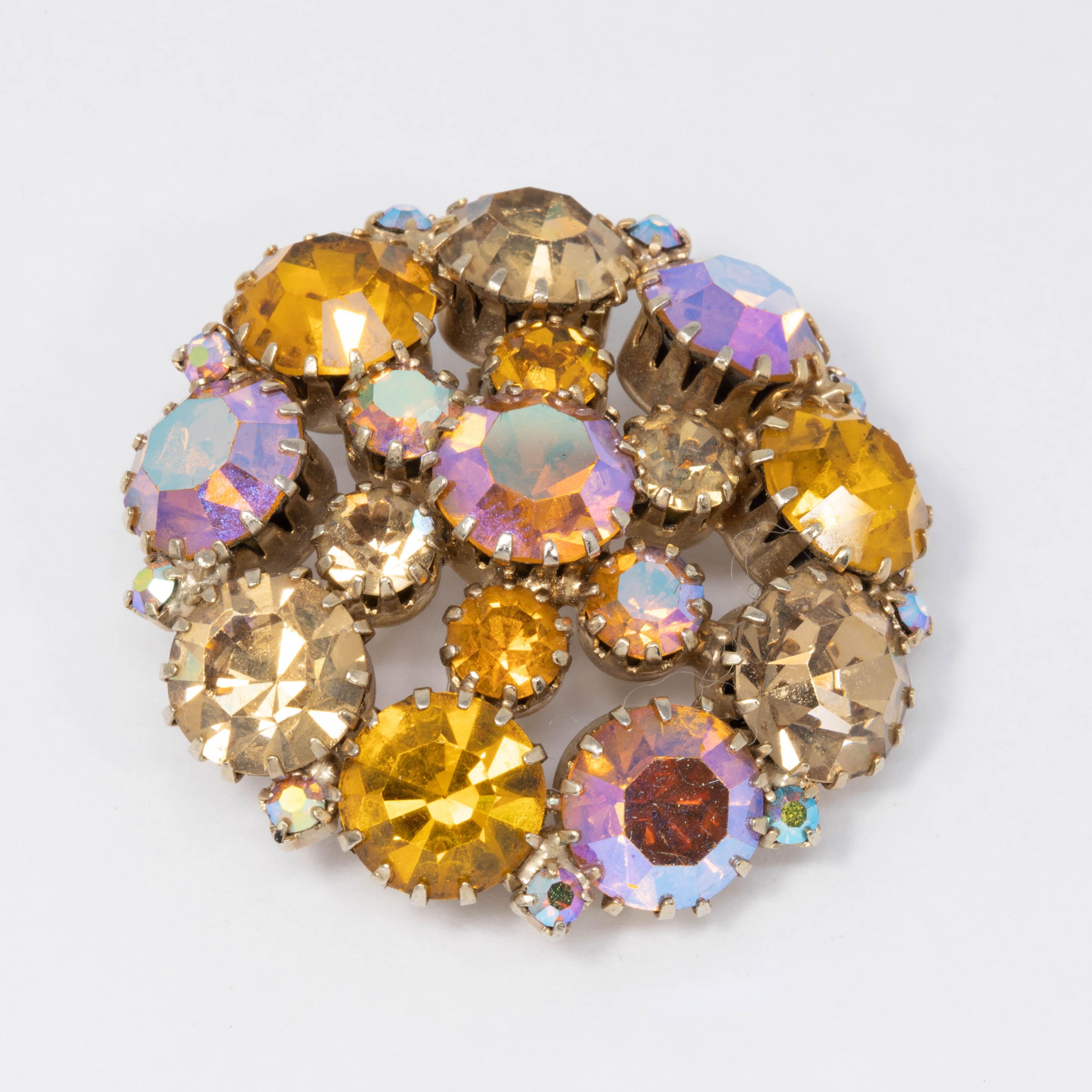 An eye-catching assortment of round-cut topaz and pink aurora borealis crystals are prong-set in this vintage goldtone pin.

The pin can swing in place a little when not fastened by the rollover mechanism, but is 100% secure.