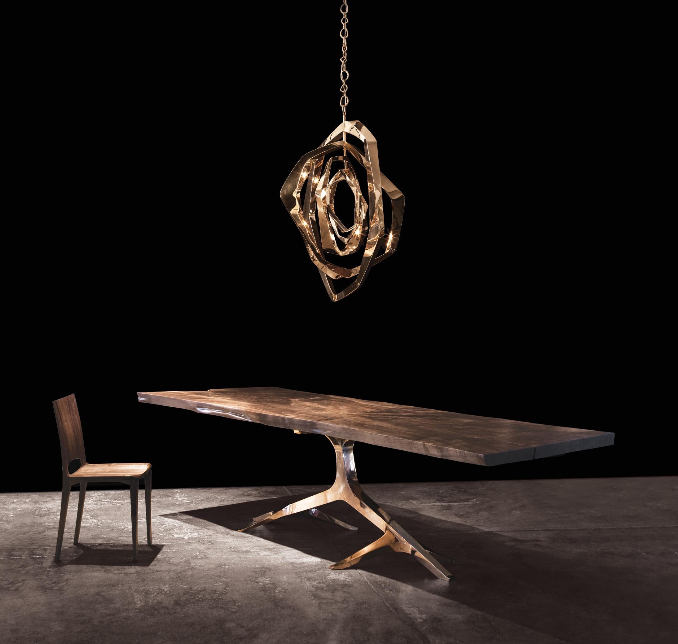 The beautiful Rose Base Dining Table by Barlas Baylar constitutes an ornate Bronze or Stainless Steel base which dances elegantly with the live, organic edges of the Live Edge top.  This solid-slab, Live Edge Walnut top is created from old growth