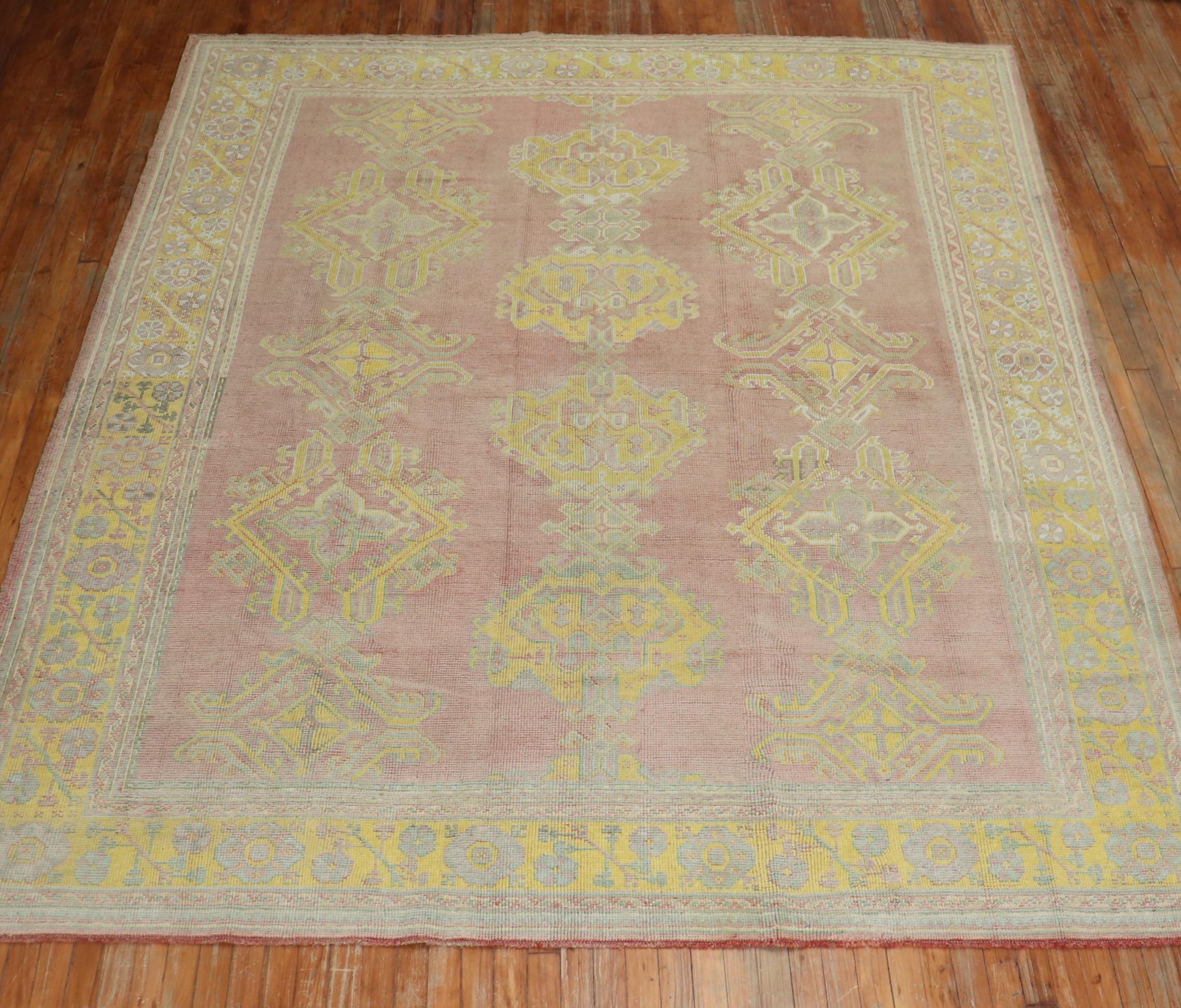 An early 20th century Turkish Oushak with an all over geometric design on aa rose field. The border is a bright yellow. Accents in bright yellow , light green and gray

Measures: 8'2