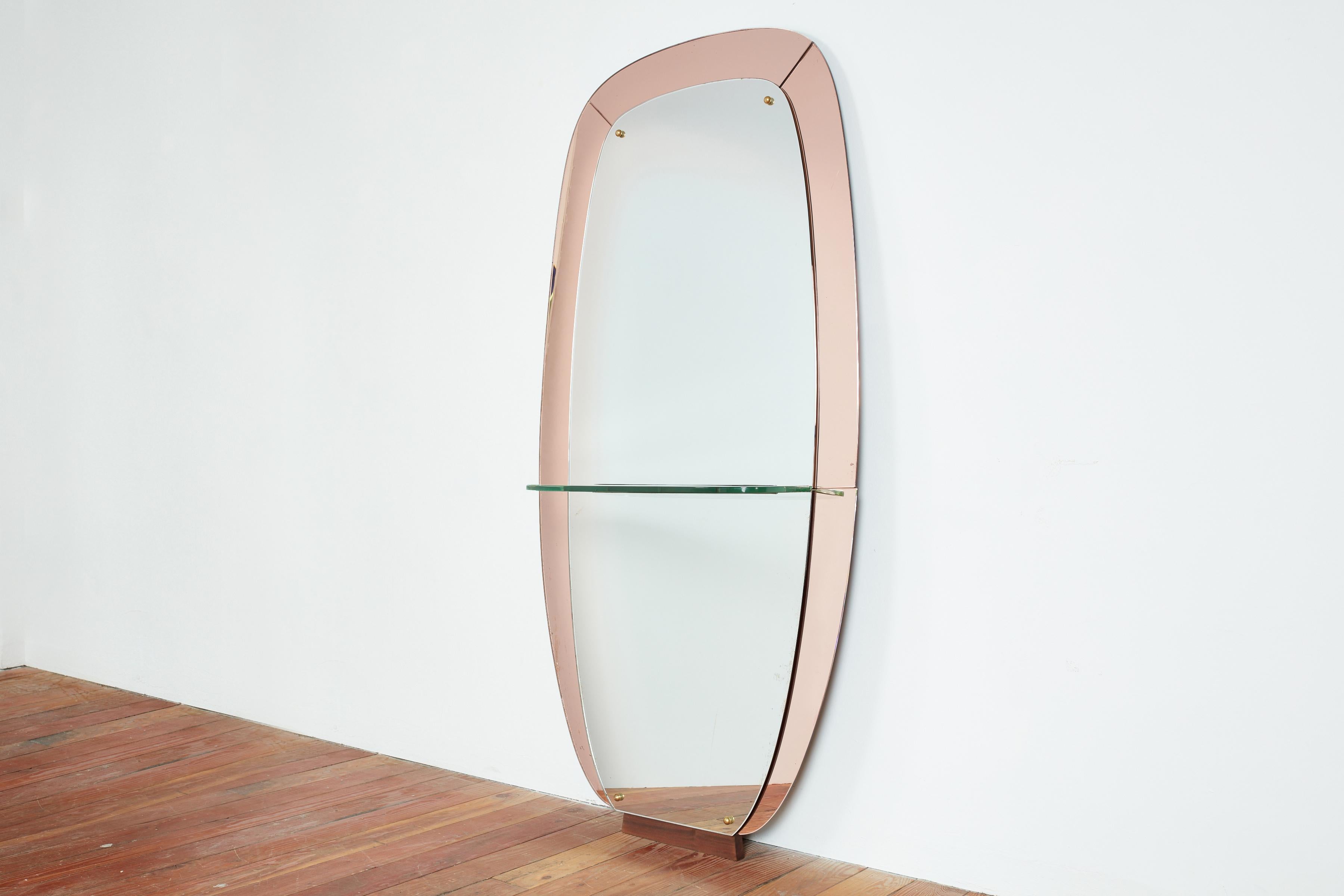 Beautiful rose colored Cristal Art Mirror with glass shelf. 
Wonderful shape with pale pink glass and glass accents - sits on a walnut wood base. 

Italy, 1950s