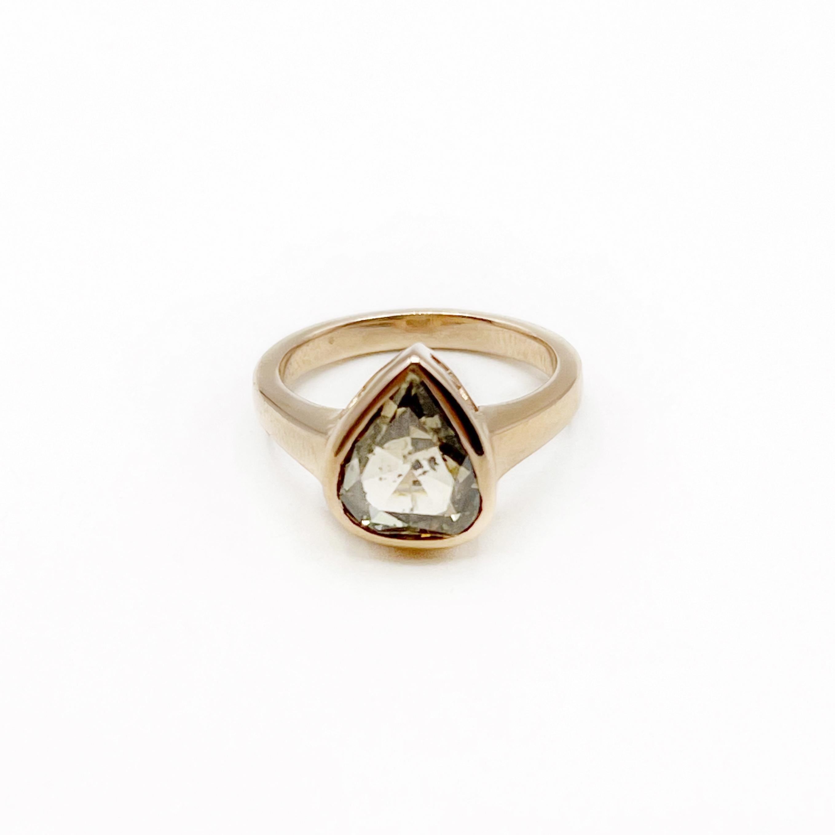 This mesmerizing diamond is a 3.07 carat pear shape rose cut with a cognac hue. The 18 karat rose gold setting is the perfect compliment for this yummy diamond. The setting has an open basket design to create a beautiful side view. Wear every day