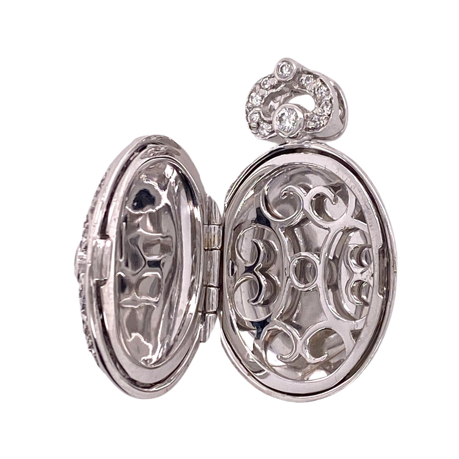 Diamond locket fashioned in `18 karat white gold. The locket features rose cut diamonds weighing approximately 1.25 carat total weight and graded H-I color and SI clarity. The pendant opens for inside photos, and measures .25 x 1.25 inches. 