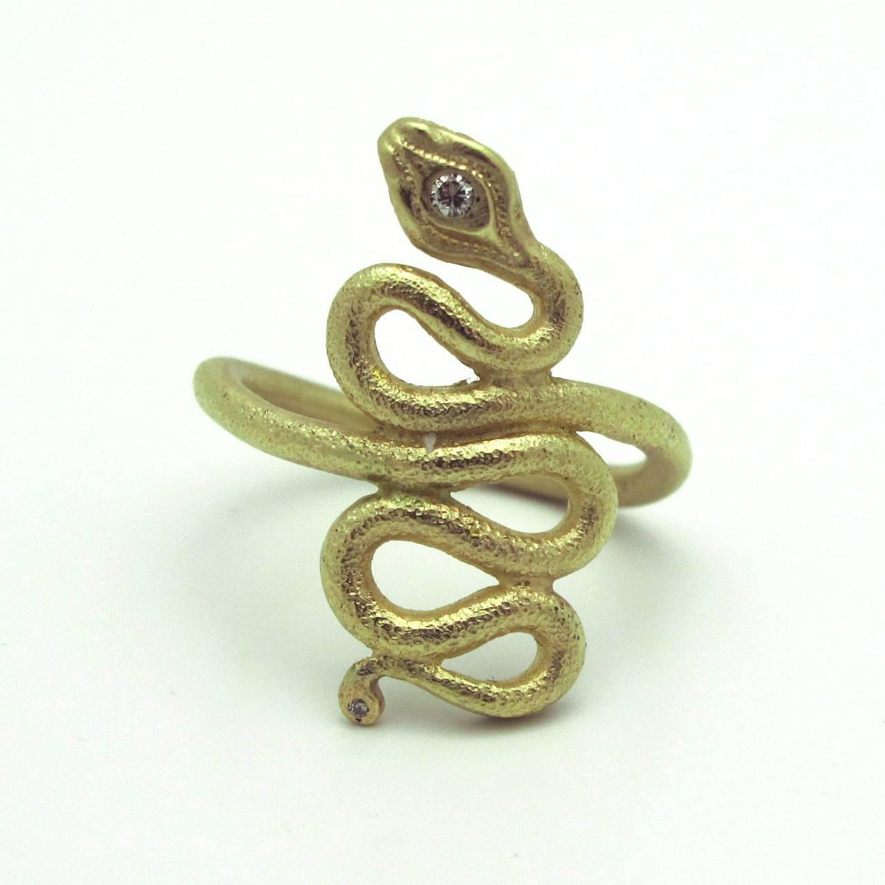 This stunning 14k Gold Snake Ring with diamond head is a classic and modern beautifully designed snake. It has a delicate reptilian texture that gives it a natural look . The head is accented with one rose cut diamond.