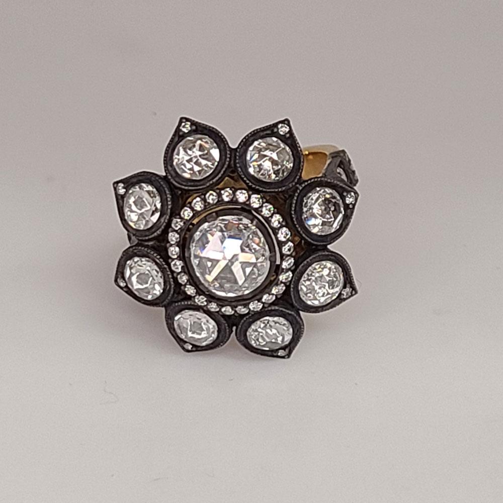 This one of a kind 18K Gold Ring has 8 rose-cut round Diamonds of 1.04cts around the center oval rose-cut Diamond of 0.57cts. The halo and the accent Diamonds complementing the rose-cut Diamonds are round brilliants of 0.35cts. This ring is 6.25 in
