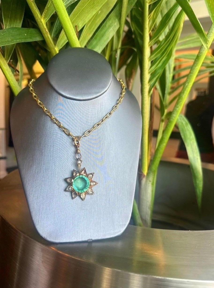 Ein einzigartiger kolumbianischer Smaragd mit Sonnenschliff, umgeben von Diamanten im Rosenschliff. Wir freuen uns, dieses Produkt rechtzeitig zu den Feiertagen in unser Angebot aufnehmen zu können. 
Diese seltene Broschen-Halskette mit Anhänger ist