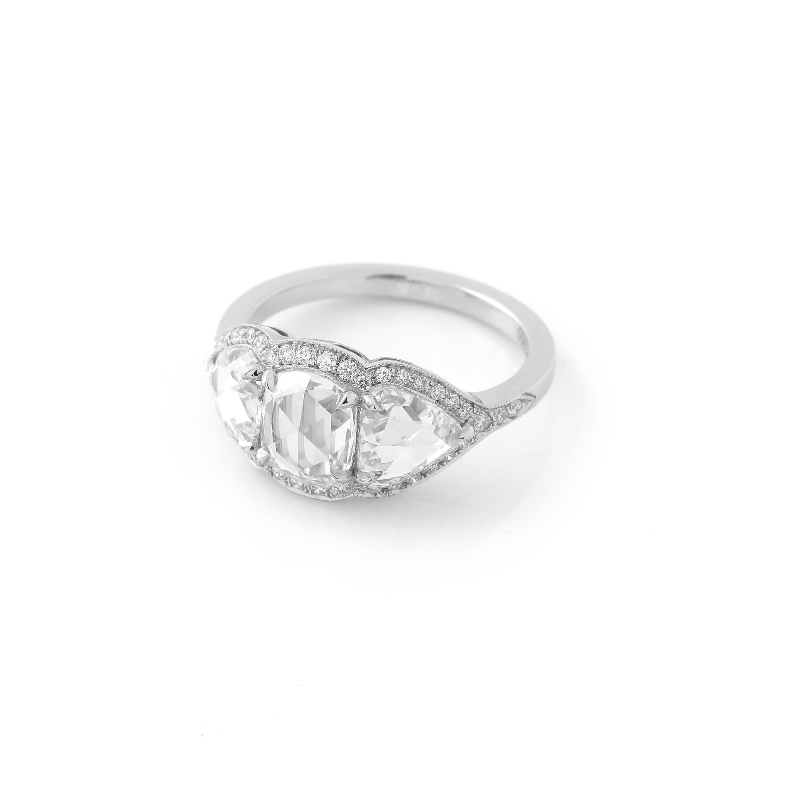 This ring features a 1.12 carat rose cut cushion diamond at its center, and a pair of beautifully matched rose cut pear shapes weighing 1.59 carats as side stones. The diamonds are not certified, but are 100% natural and approximately F to G color