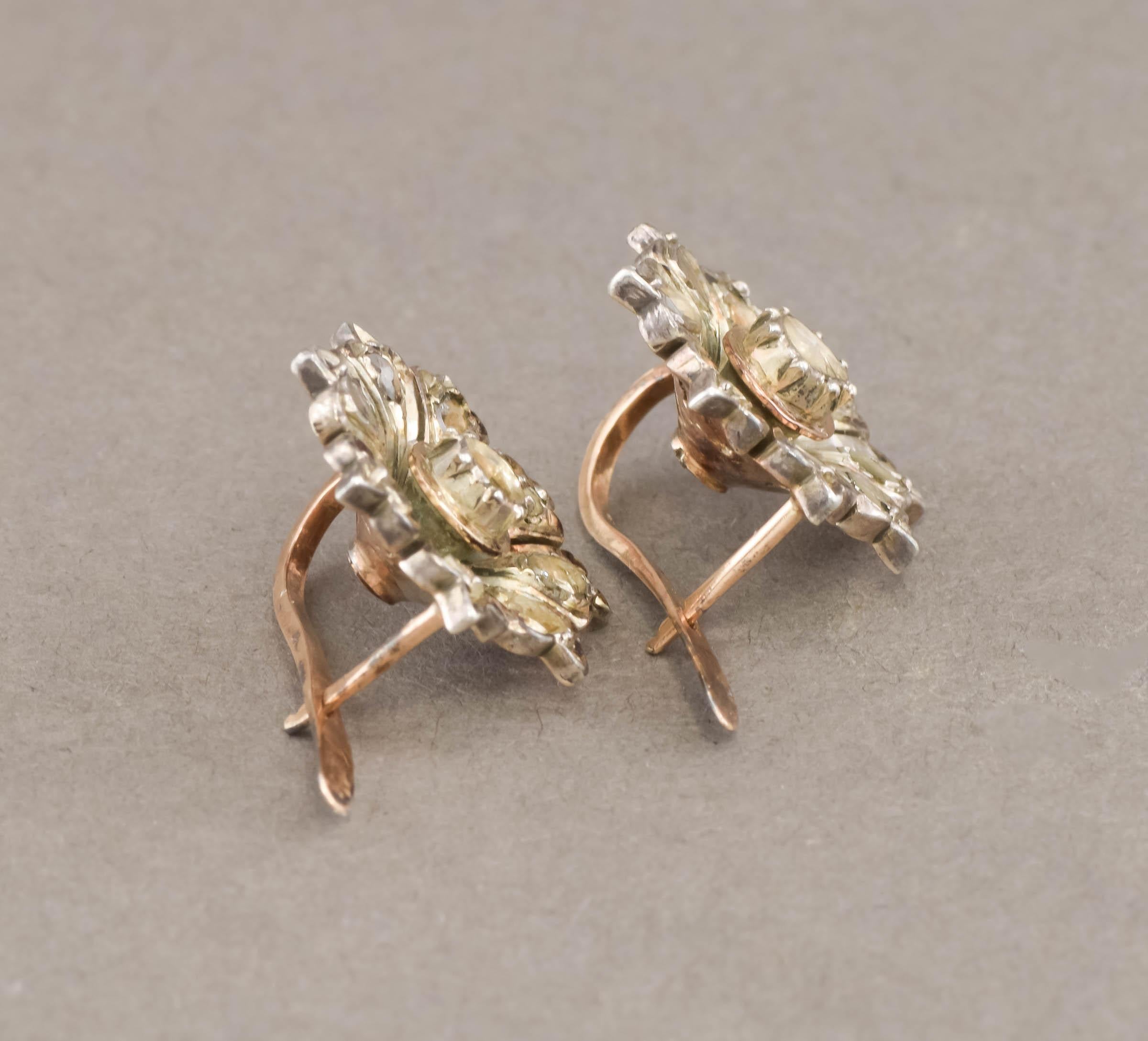 I'm pleased to offer a lovely pair of diamond flower blossom earrings in a striking Georgian to Victorian style.

Crafted of gold testing between 14K and 18K and topped with silver, the earrings feature rose cut diamonds set in a floral motif. 