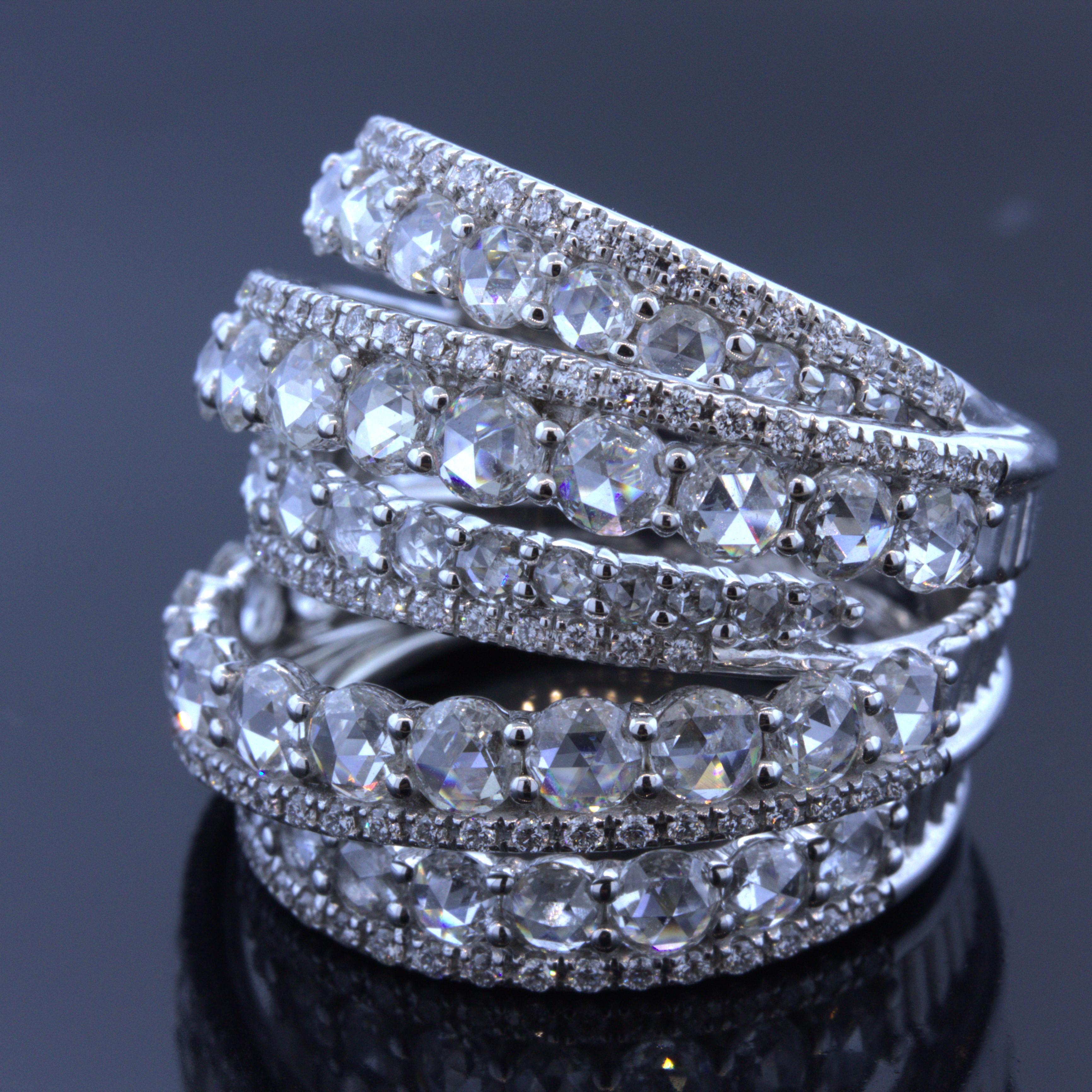 A chic, stylish, and unique diamond ring made in 18k white gold. It features 5.32 carats of fine bright white rose-cut and round brilliant-cut diamonds set over various layers of 18k white gold. It appears as if ribbons of diamonds are wrapped over