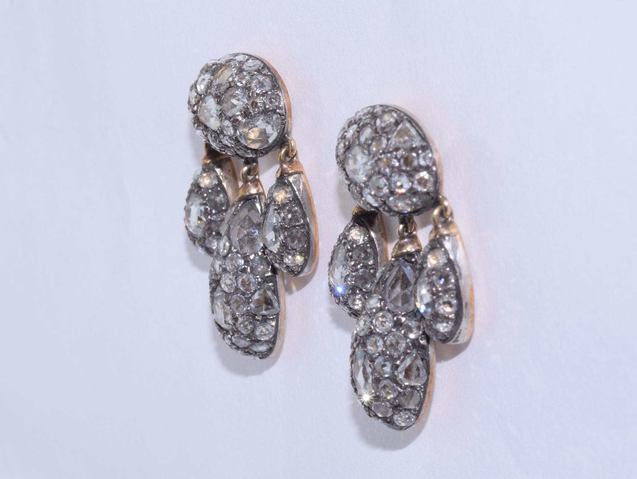 Modern girandoles are set with mixed shape rose cut diamonds totaling approximately 7.96 carats mounted in silver topped 18 karat yellow gold. The earrings measure 1 inch in length and 1/2 inch in width.