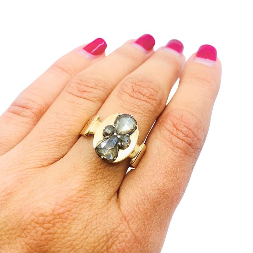 A unique rose cut diamond ring made of 14k gold.  At the center of the ring set a cluster of rose cut diamonds. The diamonds’ slightly irregular shape is typical for older hand cut stones. The prong setting holding the stones is slightly raised,
